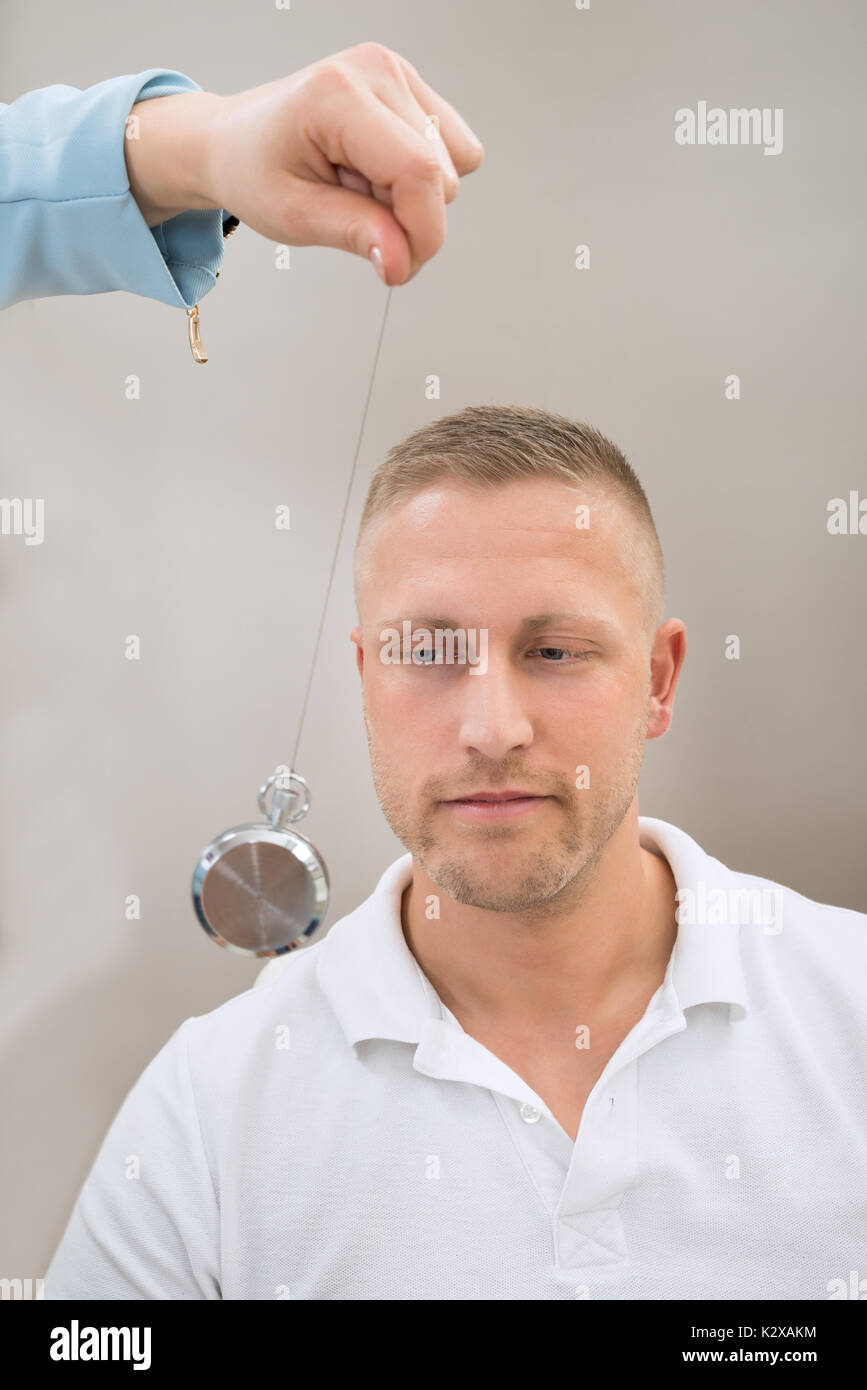 Close-up Of Psychiatrist Hypnotizing Young Man With Pendulum Stock ...