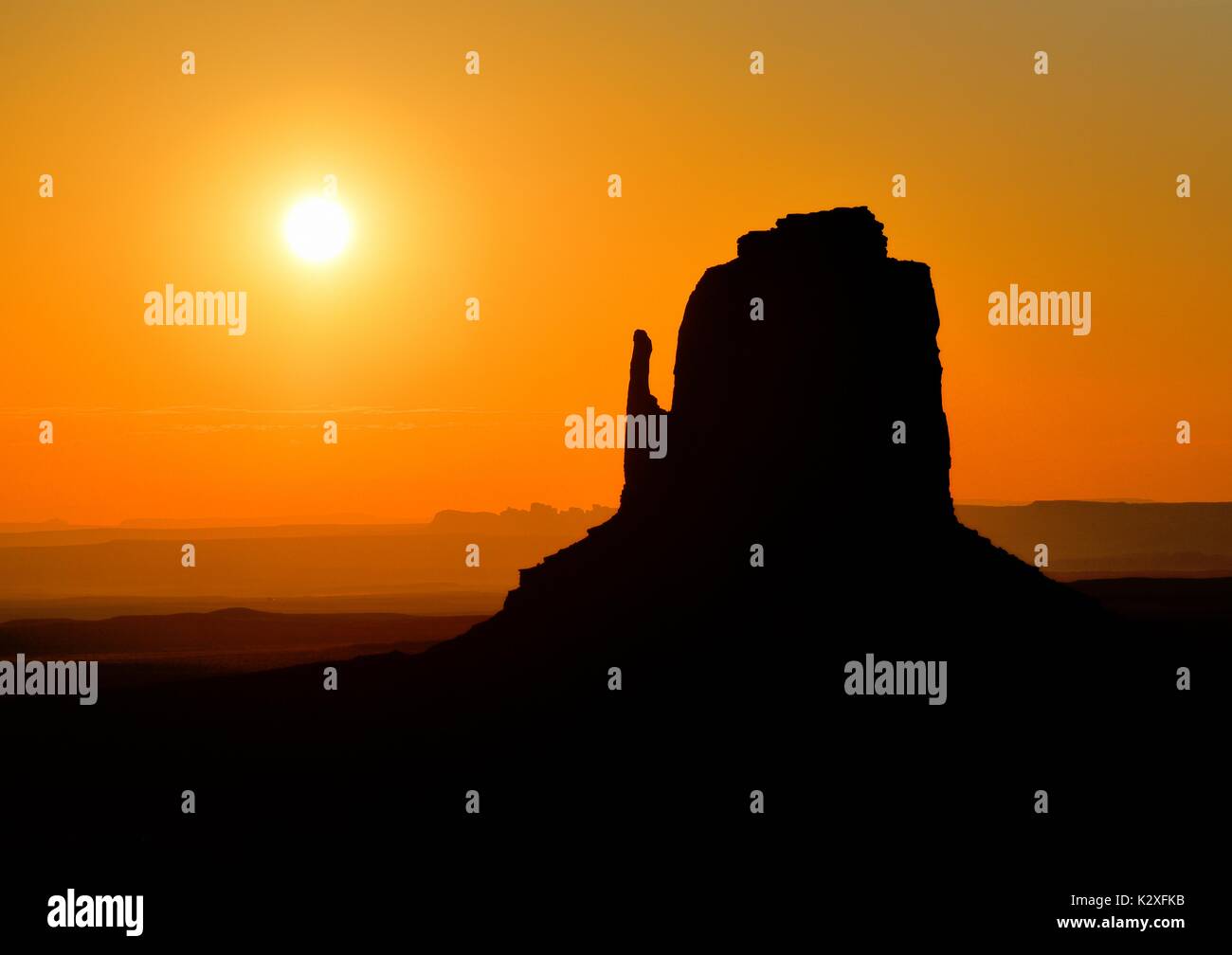 Monument Valley Arizona Perfect Sunrise - East Mitten Butte Silhouette Dawn Sunrise Sunset Mist Fog  The Mittens. Stock Photo