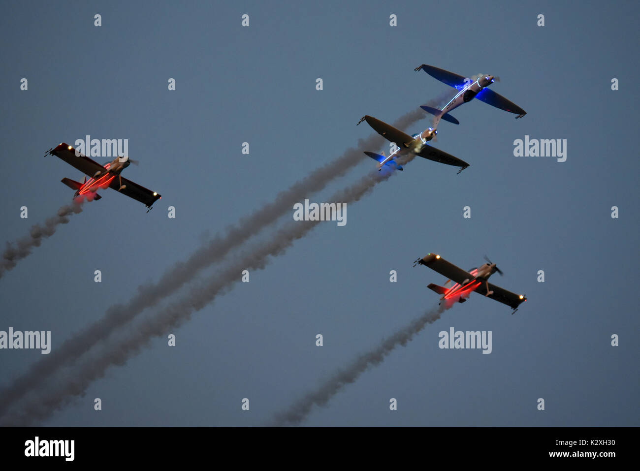 The illuminated Fireflies and Twister aerobatic teams flying together prior to their individual displays in the dusk Clacton Airshow Stock Photo