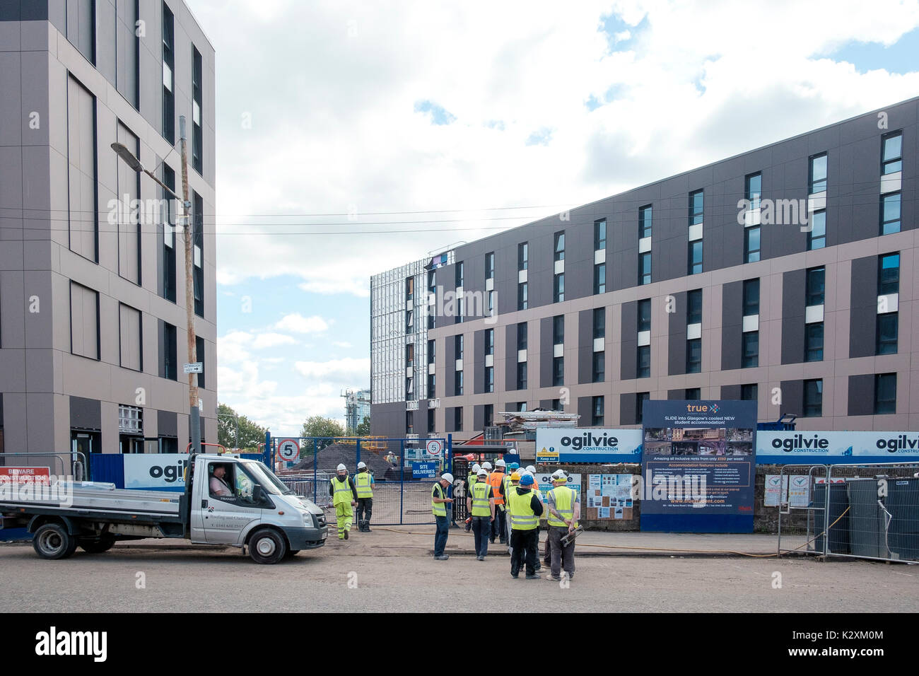 Workers queue to access Ogilvie Construction site on Kelvinhaugh Street Glasgow where new student residences are being built Stock Photo