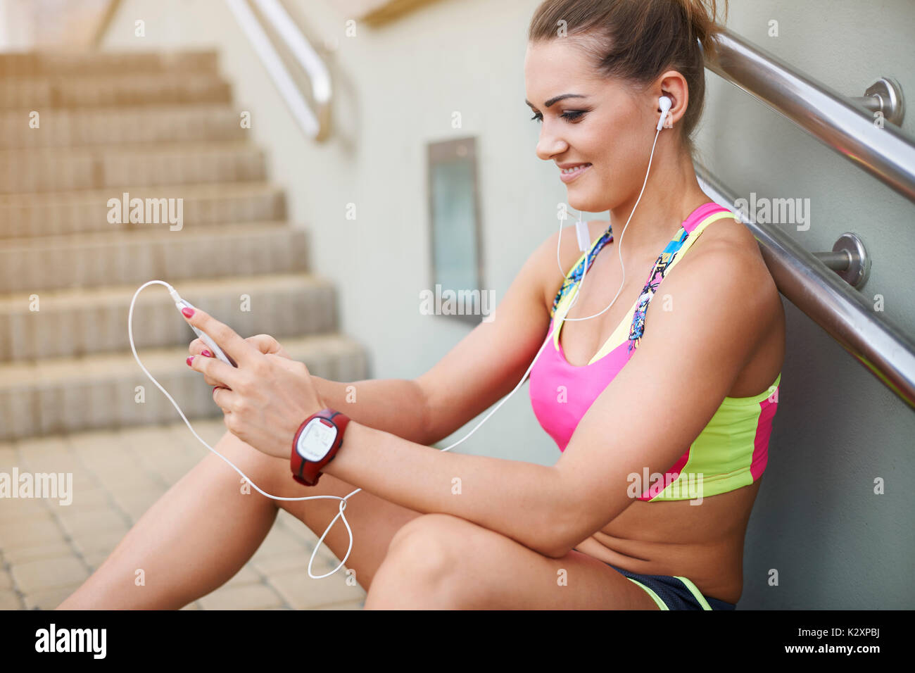 Woman in sports clothing resting on the steps Stock Photo