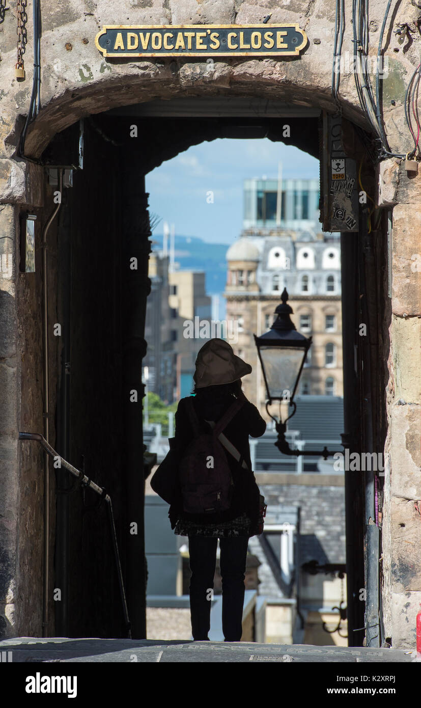 A tourists takes pictures in Advocate's Close on Edinburgh's Royal Mile. Stock Photo