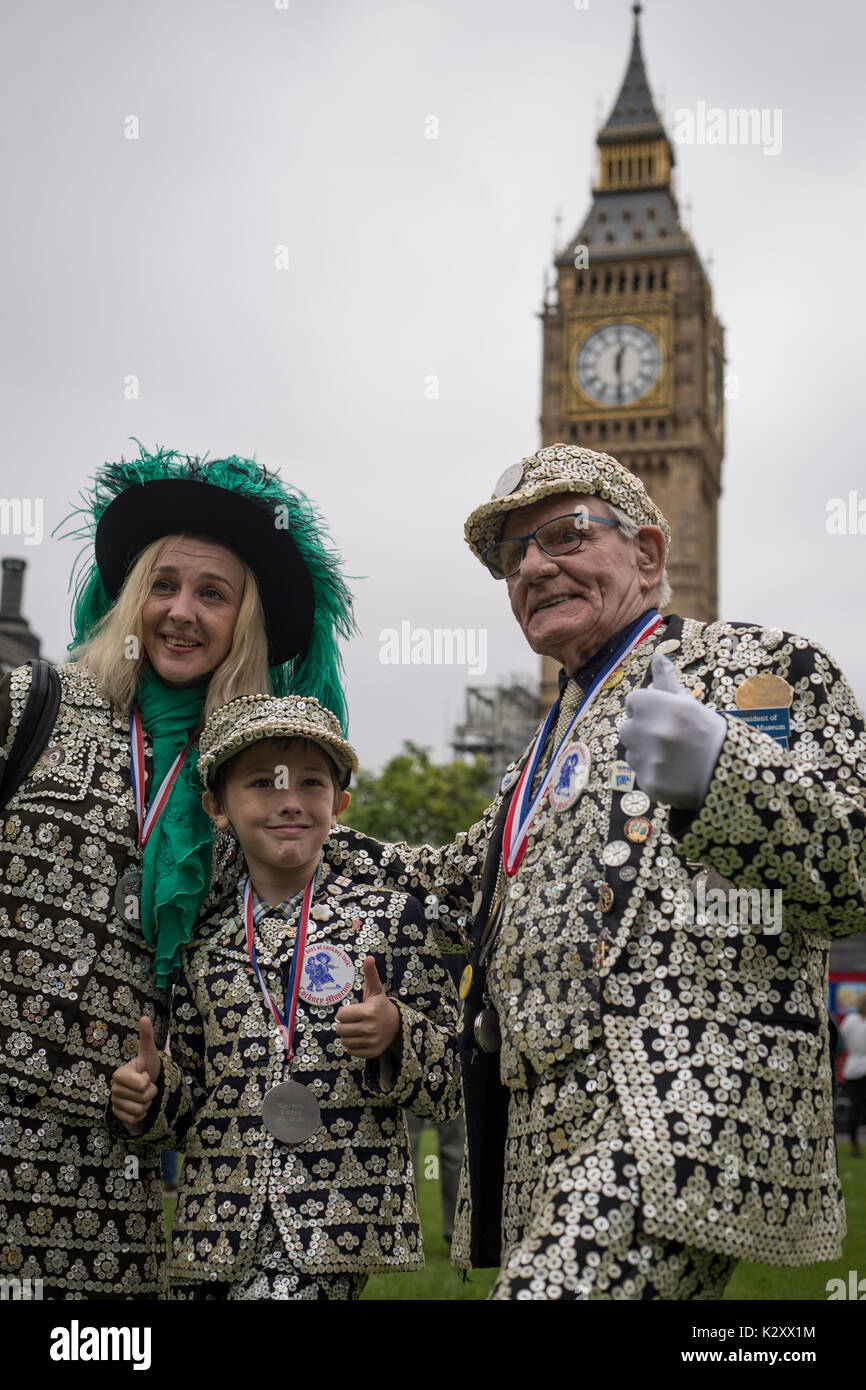 Pearly King, Queen and Prince of Peckham, in their Pearly Kings clothes, outside Houses of Parliament and Big Ben, London, England, UK. Stock Photo
