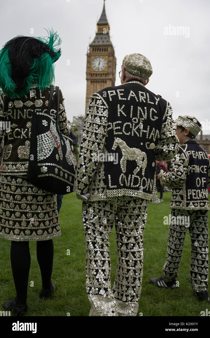 Pearly King, Queen and Prince of Peckham, in their Pearly Kings clothes, outside Houses of Parliament and Big Ben, London, England, UK. Stock Photo