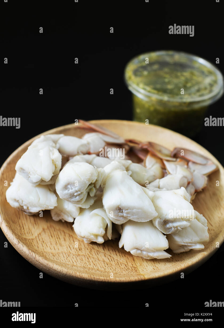 steamed crab legs with spicy sauce dip on black background, thai style