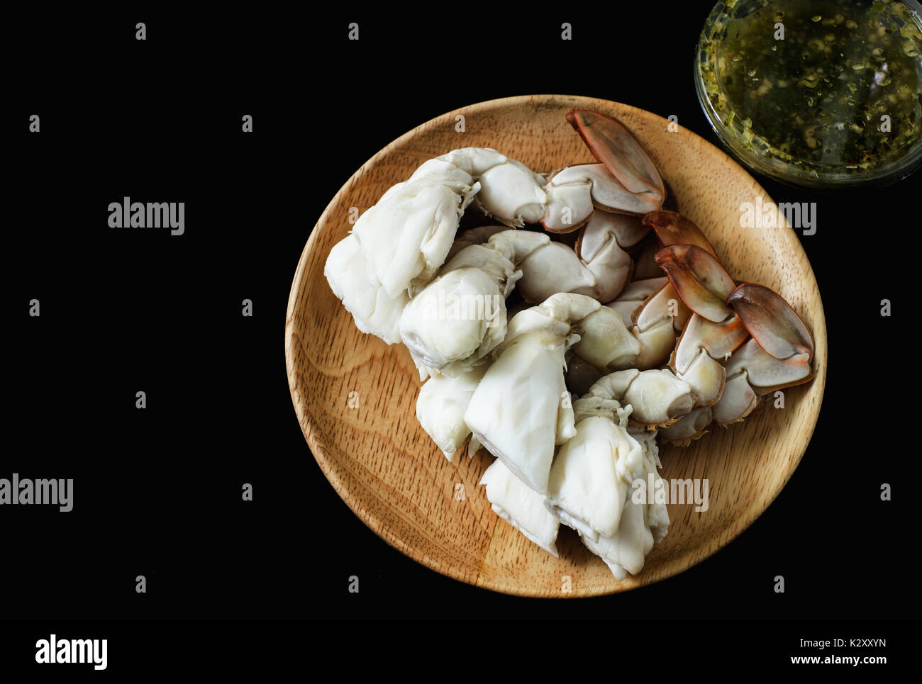 steamed crab legs with spicy sauce dip on black background, thai style
