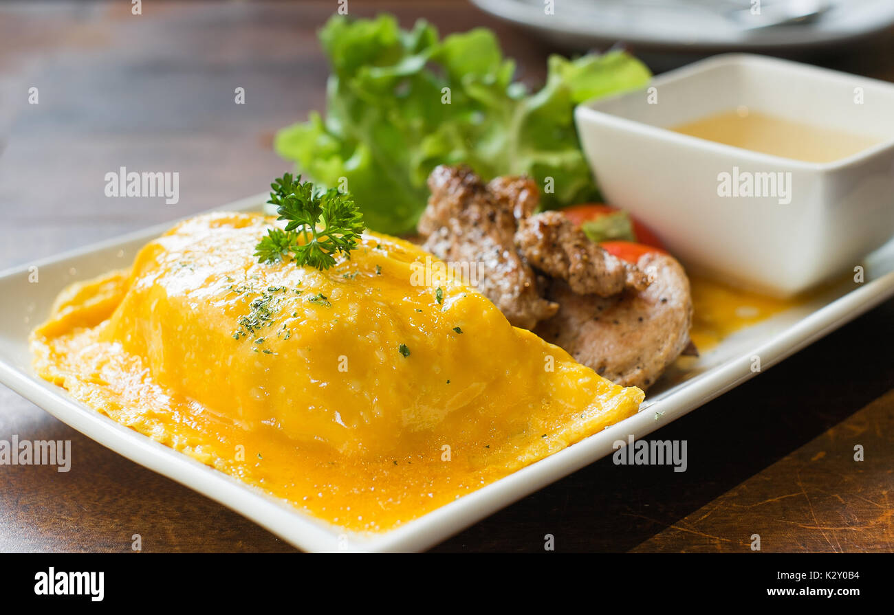 omelete rice with roasted pork on wood table Stock Photo