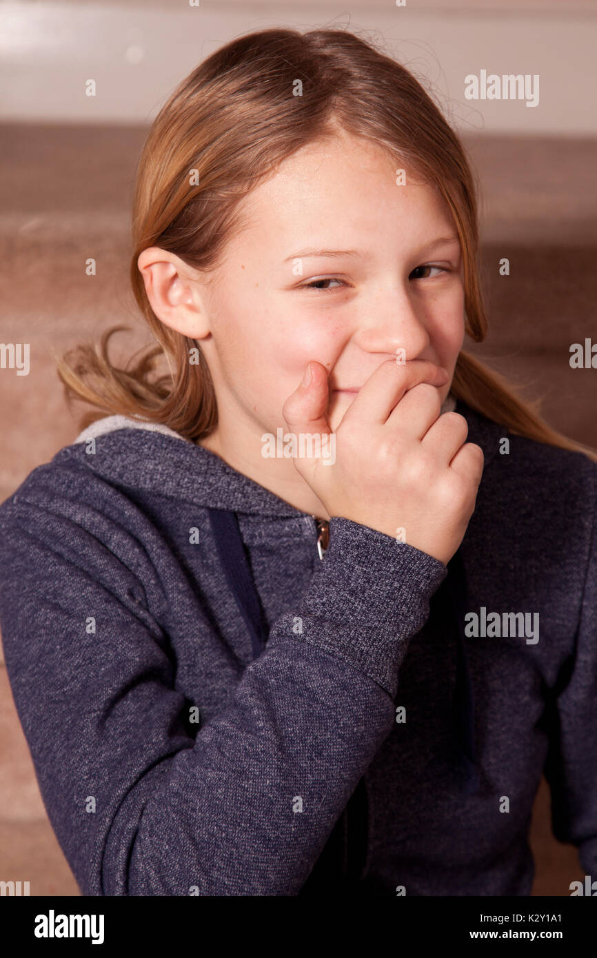 a girl covering a secret smile Stock Photo