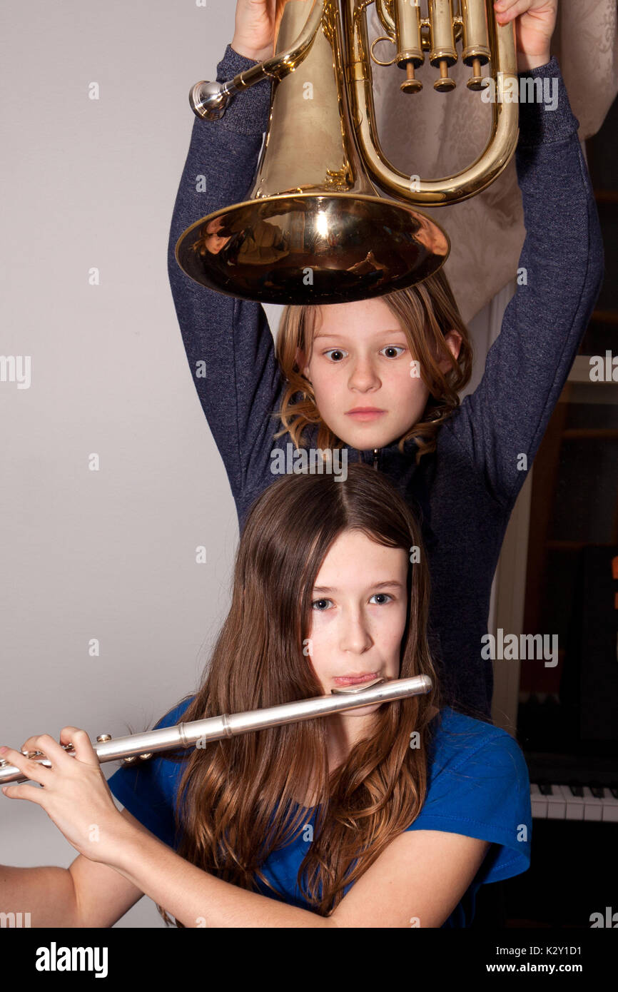 Two young girls fooling around with musical instruments. Stock Photo