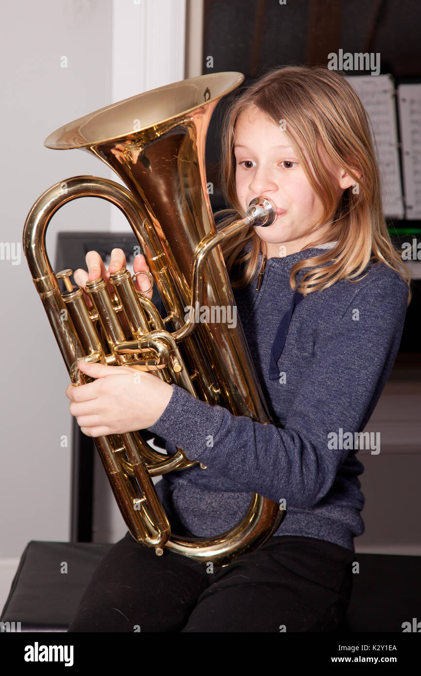 Young girl blowing on a baritone horn. Stock Photo