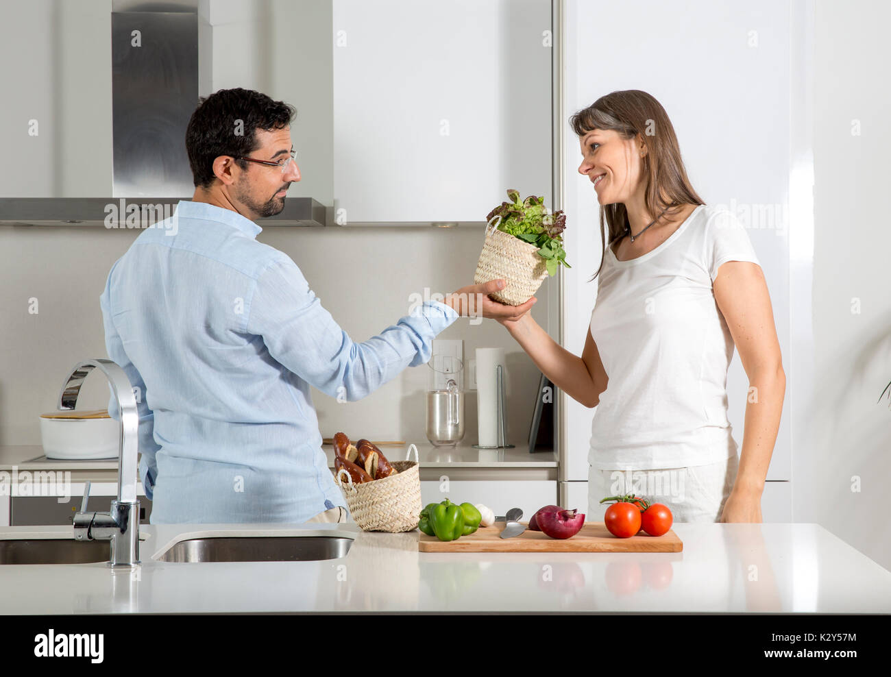 playful couple preparing food in a kitchen Stock Photo