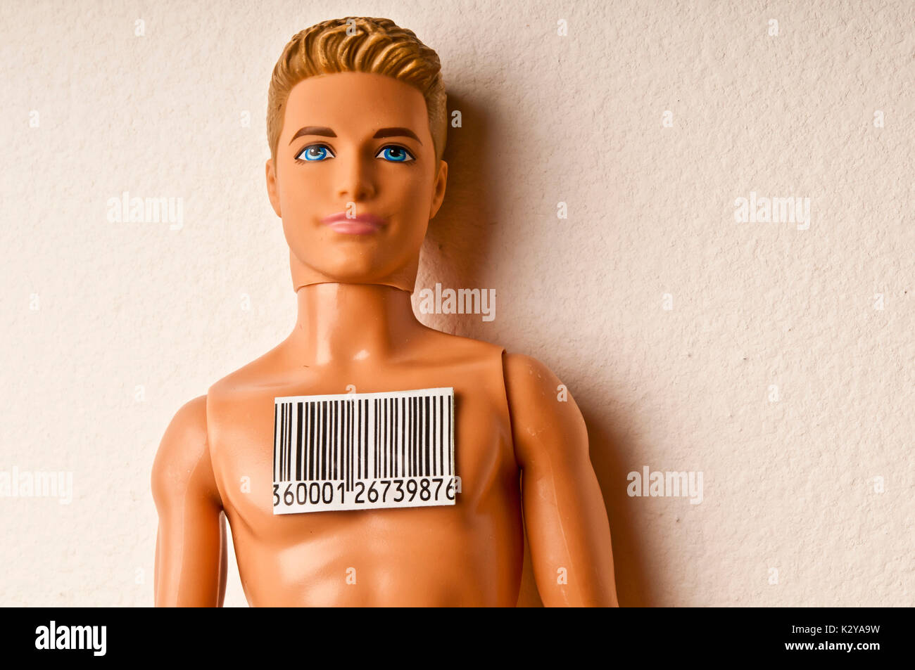 Ken doll with a bar-code attached to his chest, people as merchandise concept Stock Photo
