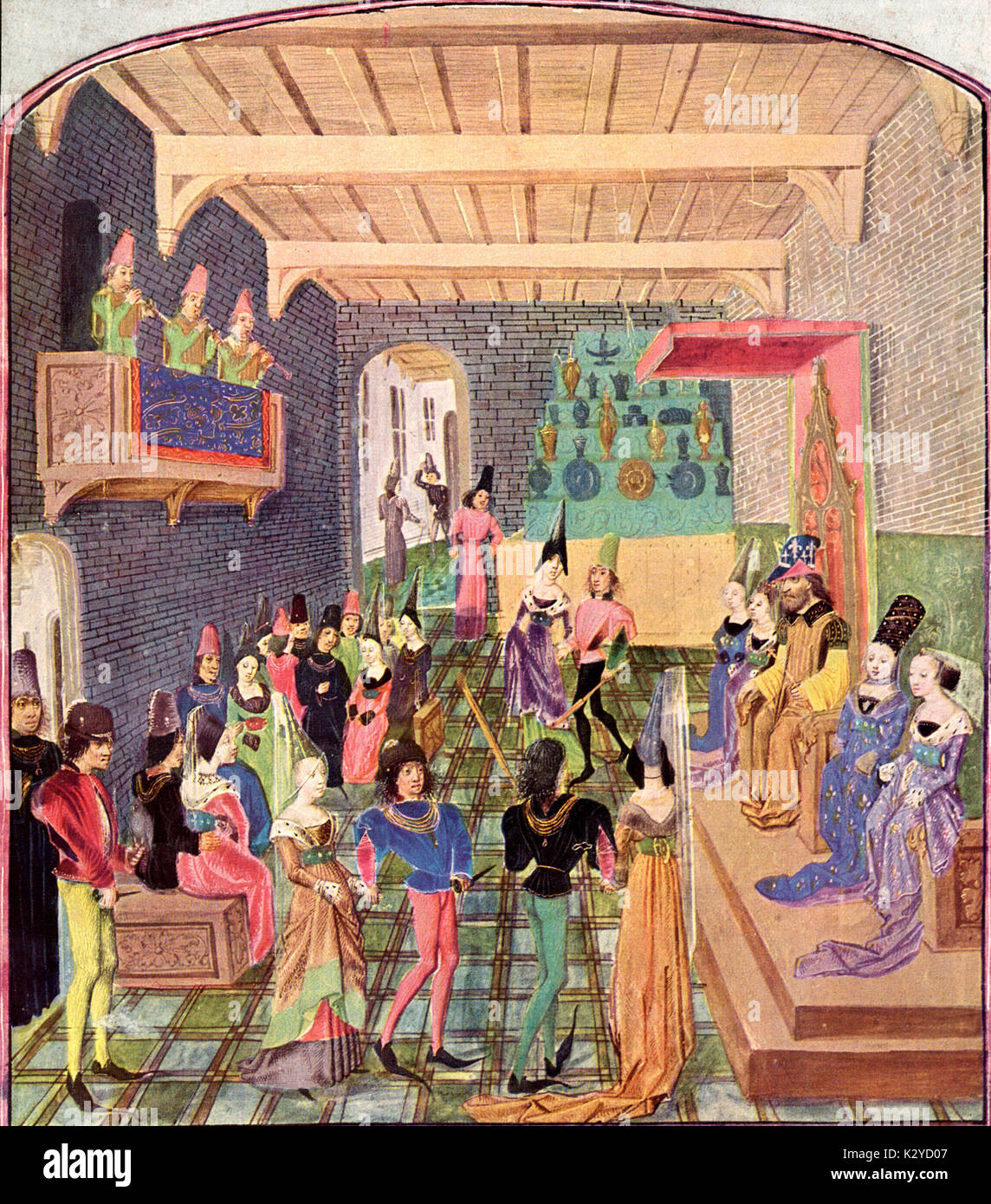 15th century England Basse dance,  with musicians playing cornettos on balcony. 15th century miniature from the English Chronicle of Jean de Waurin. Nobility sitting on dais with couples dancing.  Banquet, feast, party. Stock Photo