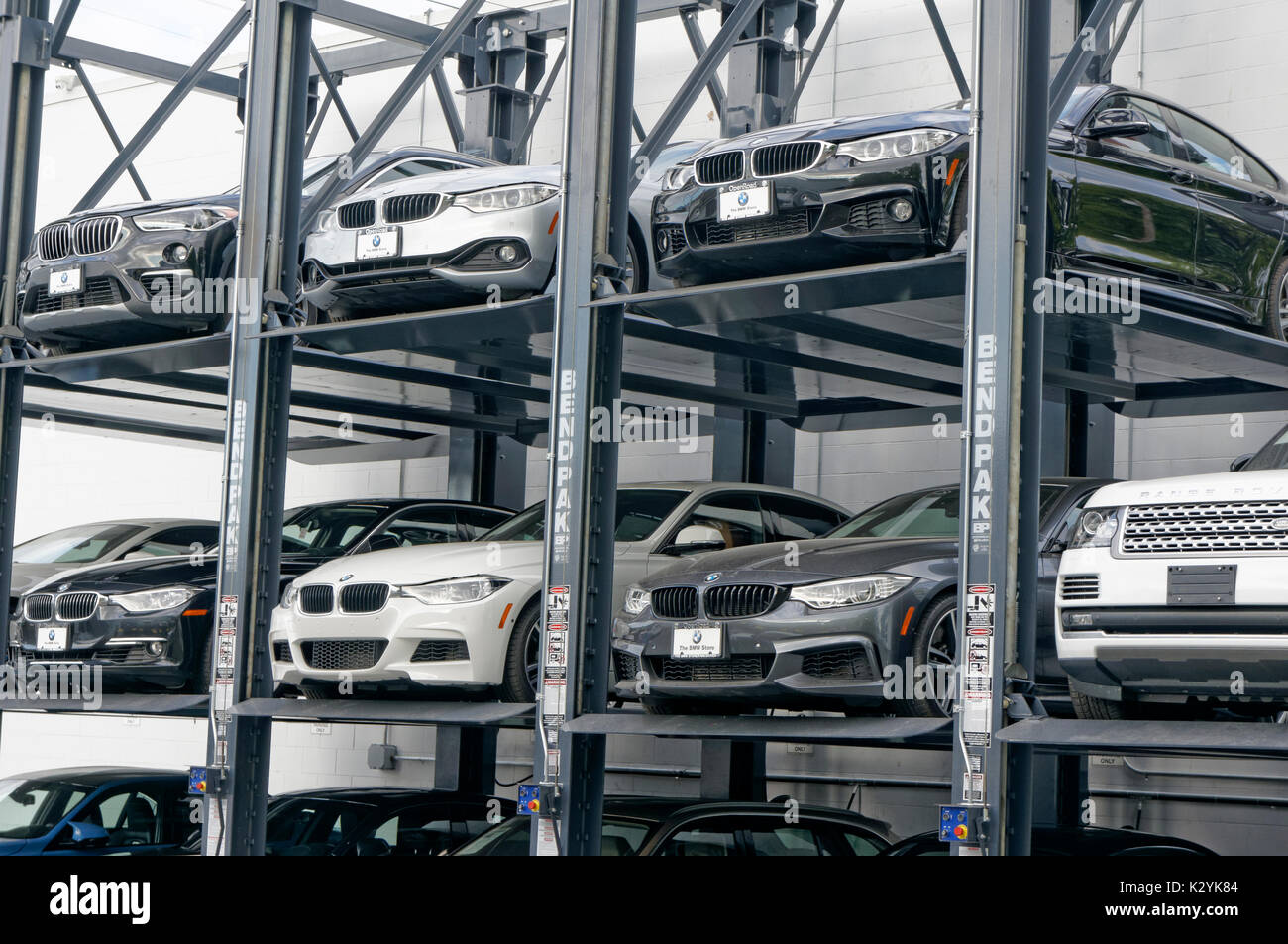 New luxury automobiles parked on a multiple level elevator car rack at the BMW Store dealership in Vancouver, BC, Canada Stock Photo
