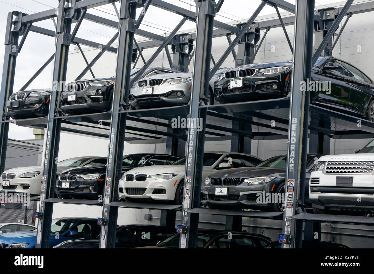 New luxury automobiles parked on a multiple level elevator car rack at the BMW Store dealership in Vancouver, BC, Canada Stock Photo