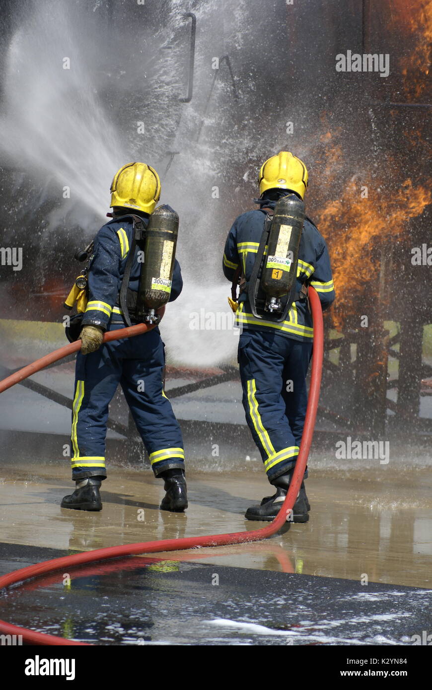 fire fighter with hose Stock Photo - Alamy