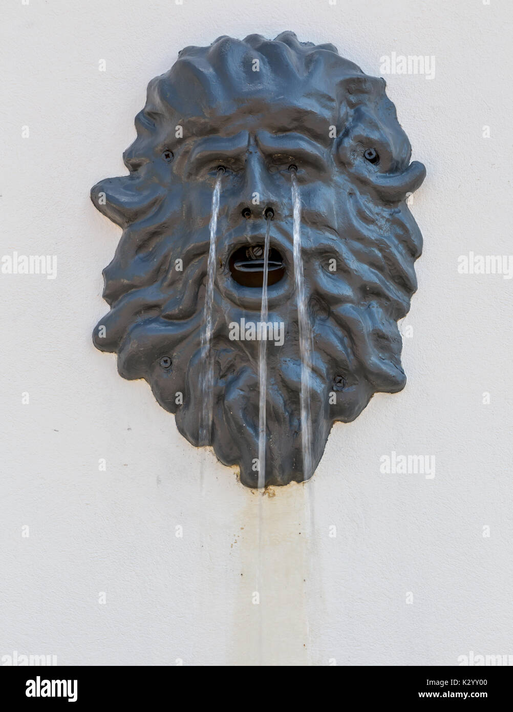 Fountain in the form of a man's head. The image of a Man's Head. Old rusty fountain Stock Photo