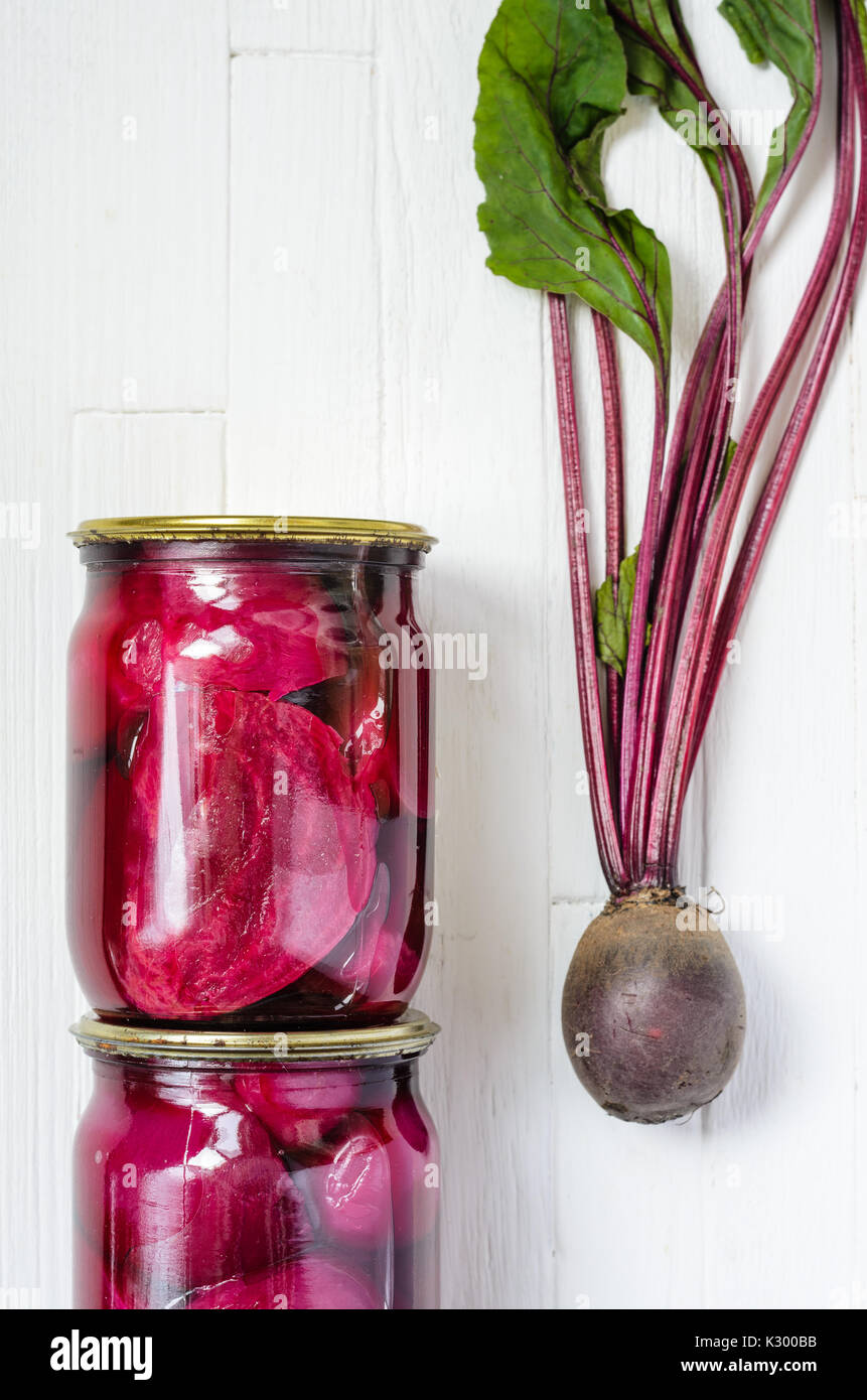 Two glass jars with canned beets home made and fresh organic beets with
