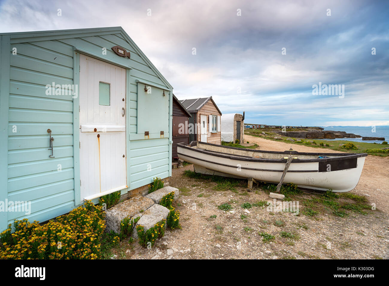 Beach huts and a boat under a moody sky at Portland Bill near Weymouth ...