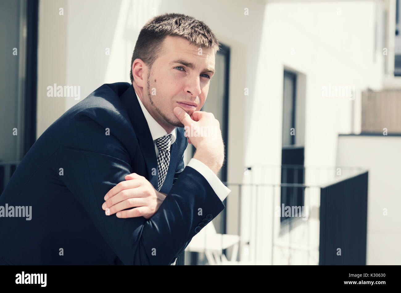 Handsome businessman enjoying view of the city from a balcony. businessman apartment handsome city style people caucasian balcony concept Stock Photo