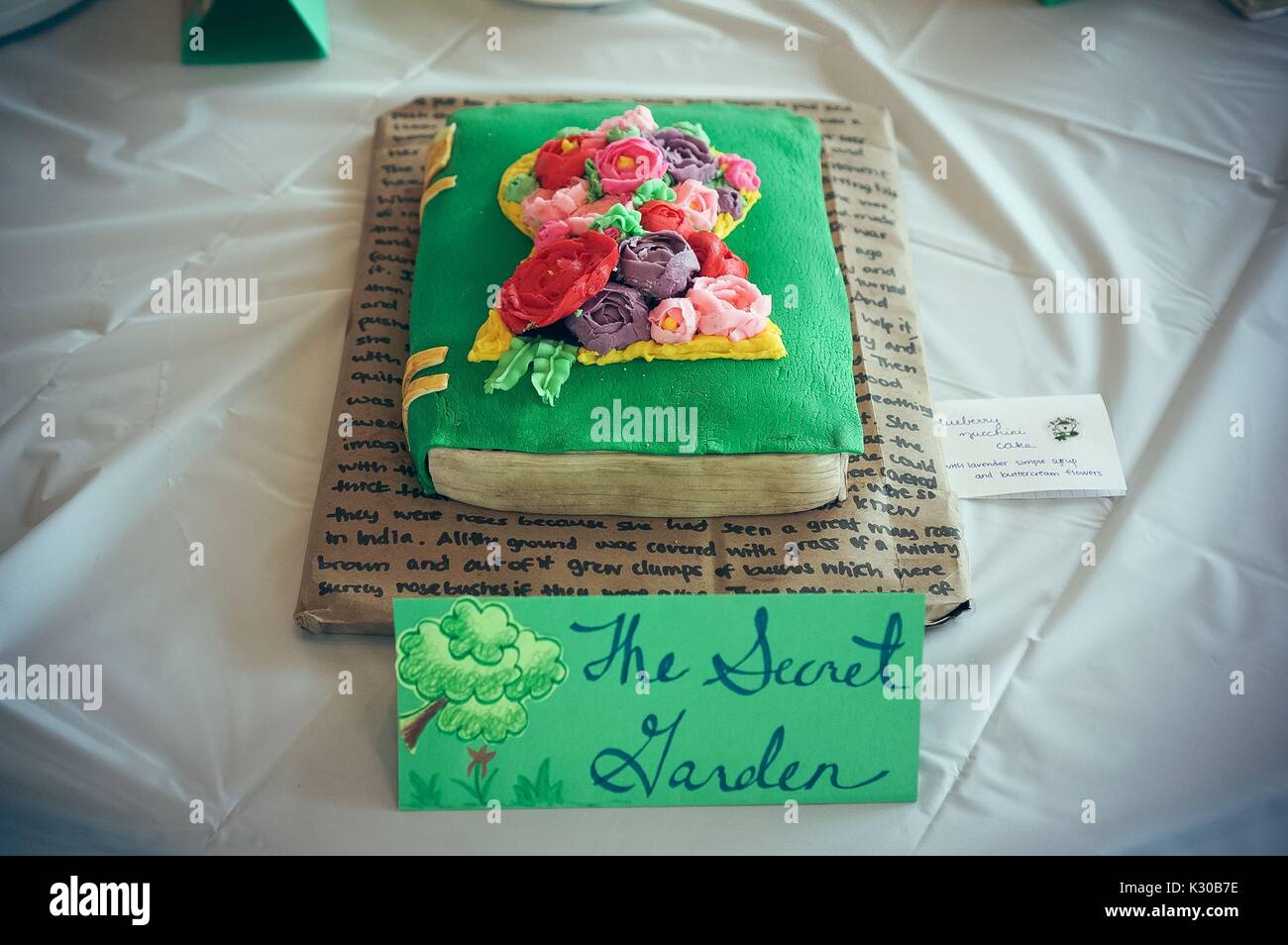 Submission for Read It and Eat It contest, and edible book festival at Milton S Eisenhower Library, Johns Hopkins University, showing a cake made of a green book with flower bouquet from frosting, and a page of text underneath, for the theme 'The Secret Garden, ' Baltimore, Maryland, April, 2016. Courtesy Eric Chen. Stock Photo