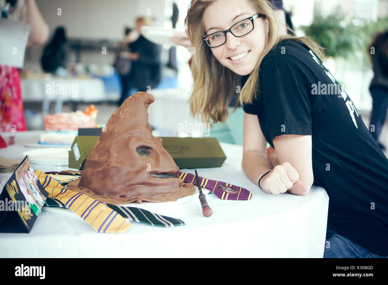 An undergraduate college student stands with her Harry Potter cake during Johns Hopkins University's annual 'Read It And Eat It' Edible Book Festival on the Homewood campus in Baltimore, Maryland, March, 2016. Courtesy Eric Chen. Stock Photo