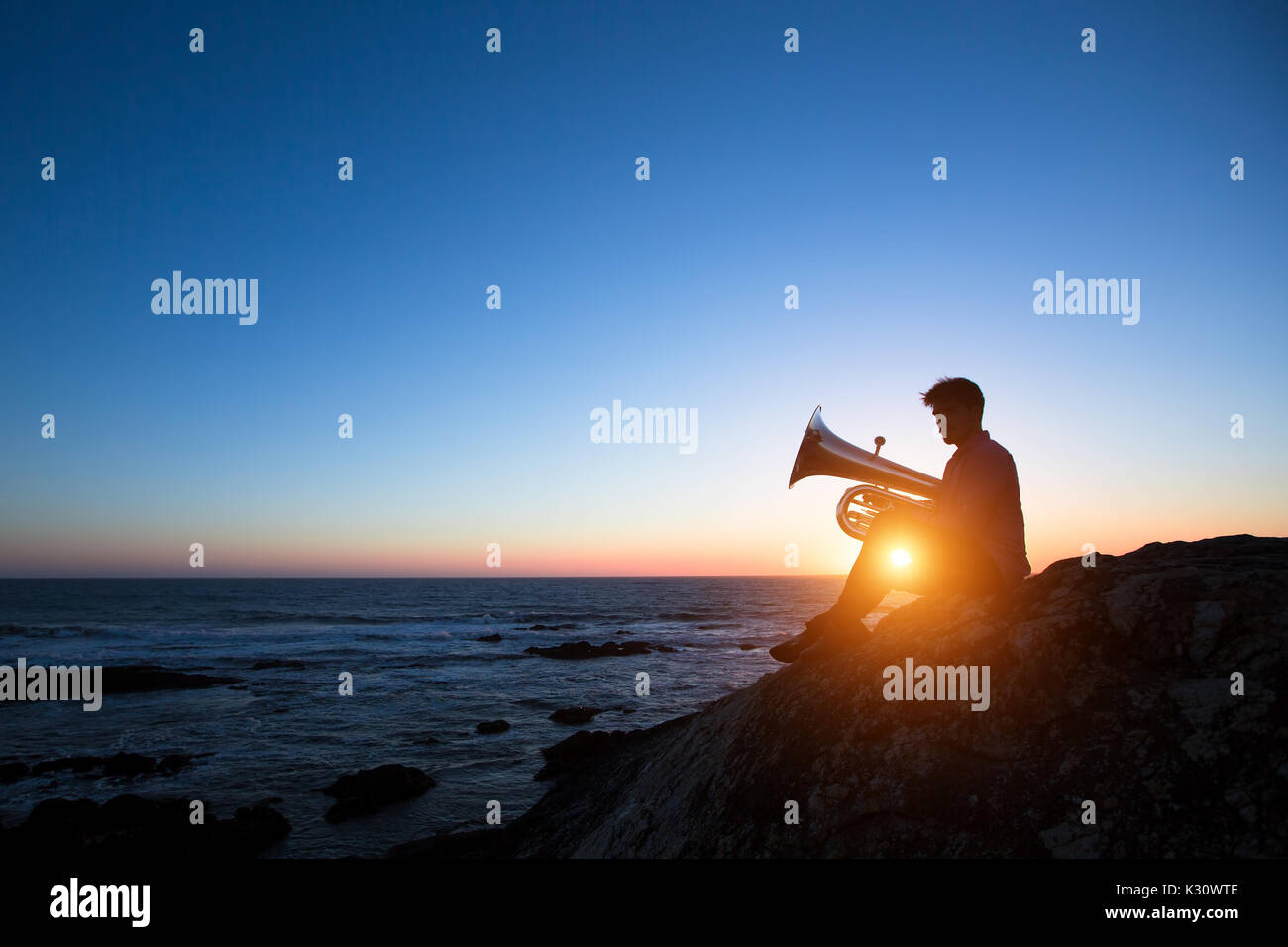 Silhouette of a man playing the trumpet with a blue background