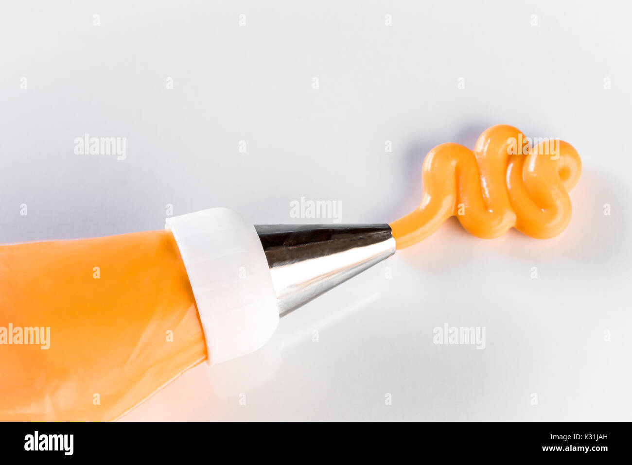 Orange frosting in a piping bag Stock Photo Alamy