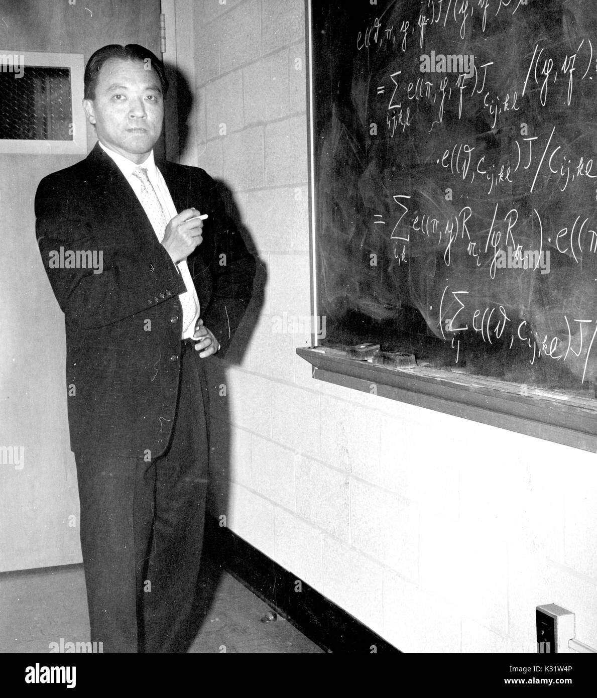 Mathematician Wei-Liang Chow writes on a chalkboard at Johns Hopkins University, where he was a professor, in Baltimore, Maryland, 1955. Stock Photo