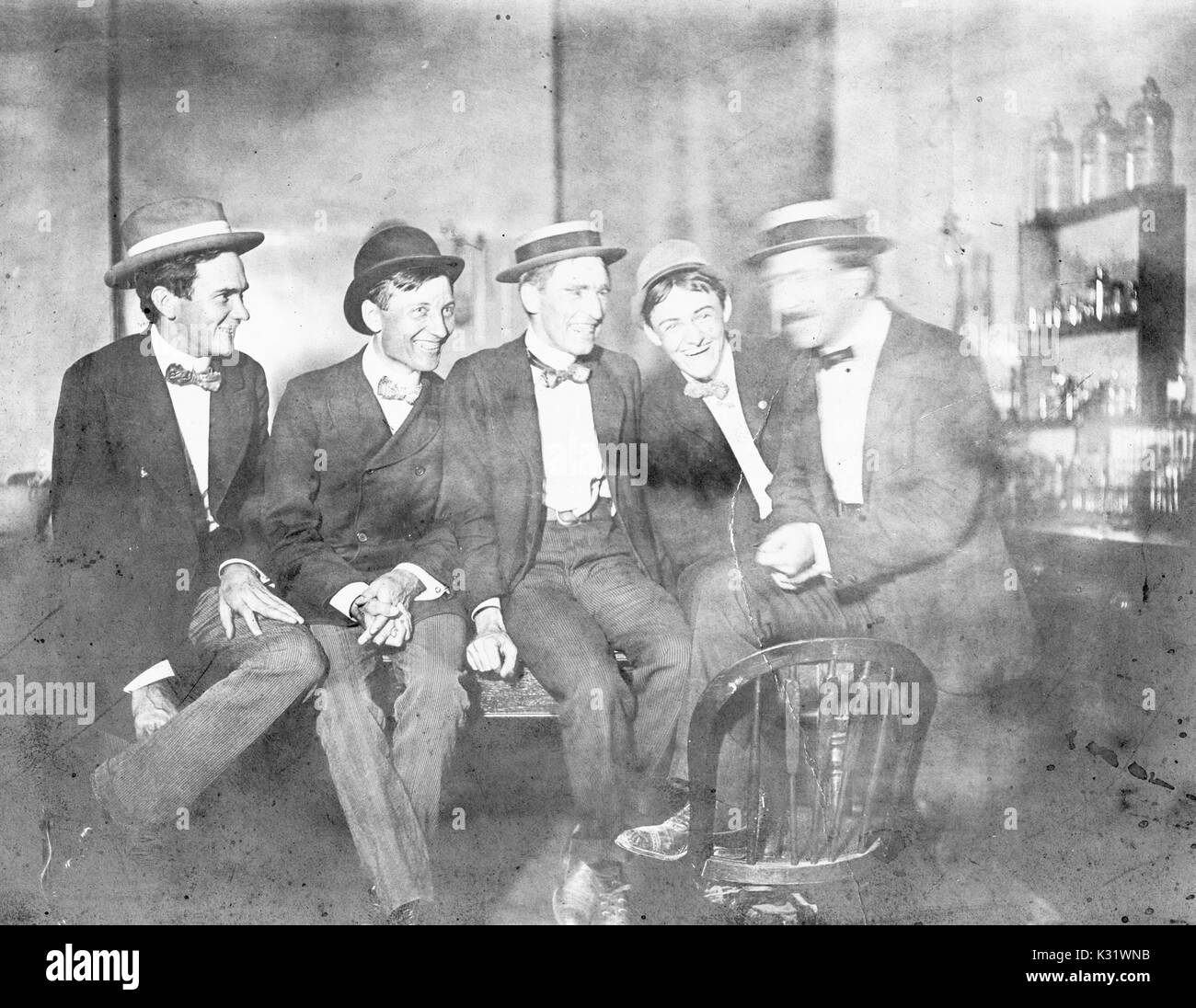 Group photograph of 1901 Johns Hopkins University PhDs in a laboratory, wearing skimmer hats and sitting in a row on a table, with smiling facial expressions, 1901. Stock Photo