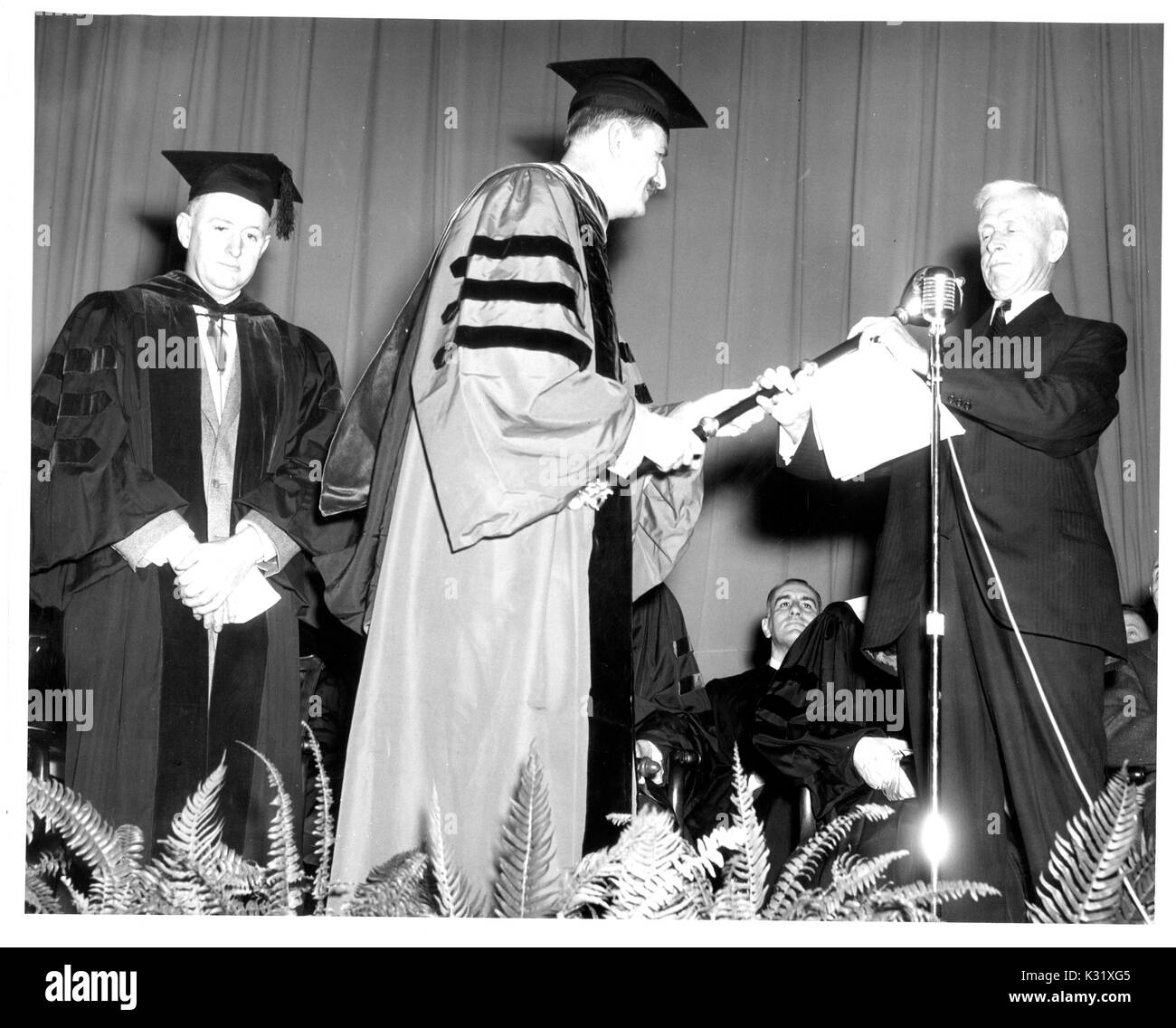American medievalist Sidney Painter presents the Johns Hopkins University mace to President of the Board of Trustees Carlyle Barton at the university's Commemoration Day, celebrating the founding of the university, in Baltimore, Maryland, February 22, 1954. Stock Photo