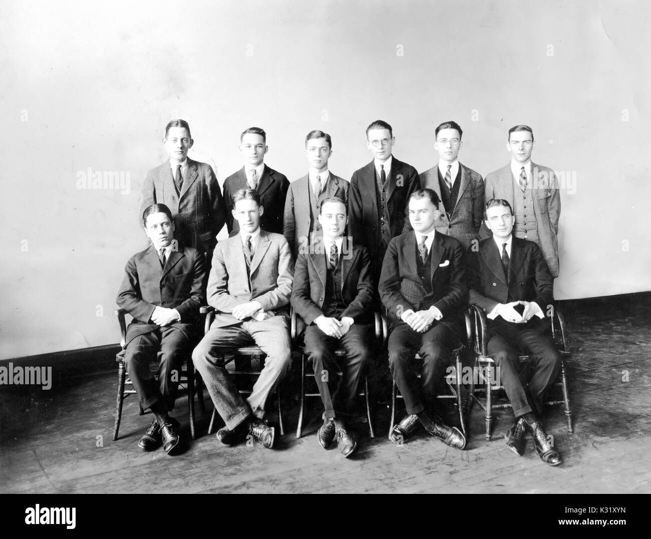 Sepia portrait photograph of members of the Christian Service Board at Johns Hopkins University, with five males seated with ankles crossed in the front row and six males standing behind with hands at sides, all wearing suits, Baltimore, Maryland, 1923. Stock Photo