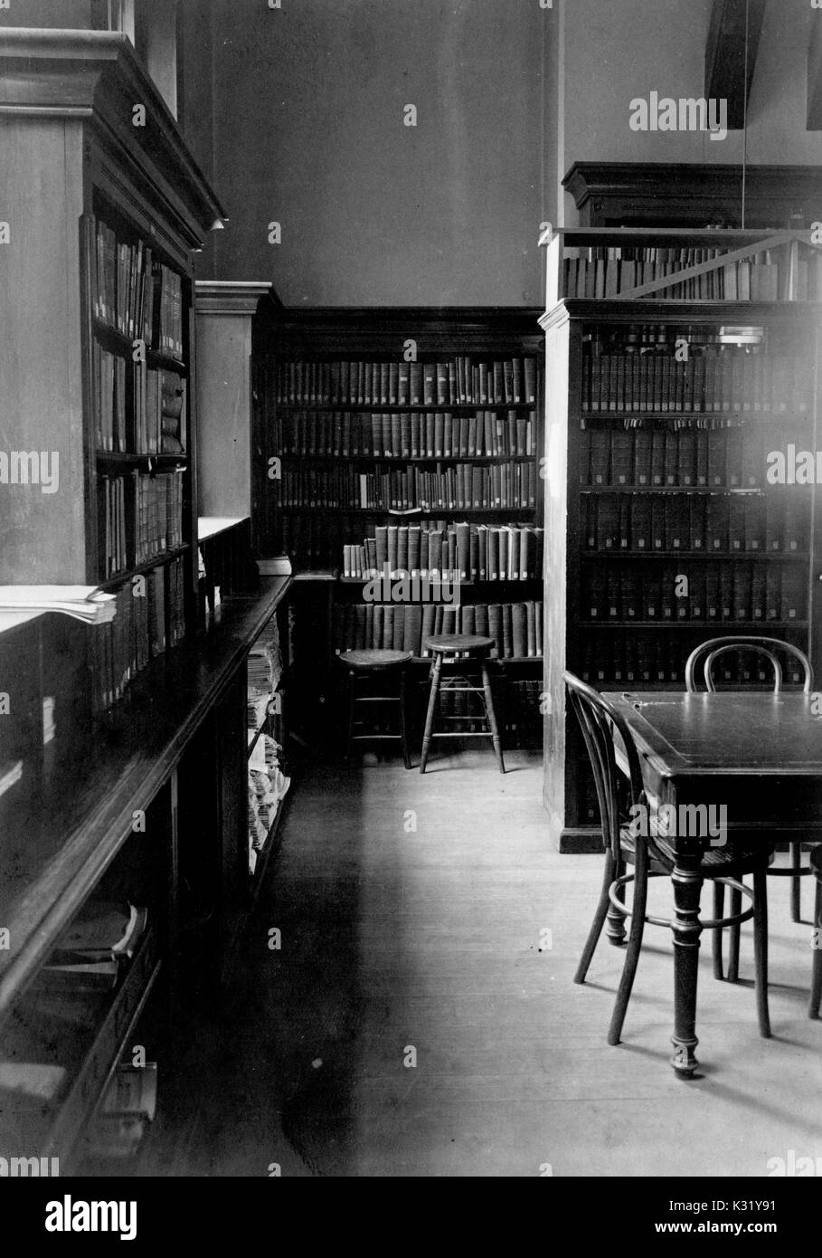Sepia photograph of the library inside the Chemistry Building at Old Campus Johns Hopkins University, showing browsing tables with chairs in between stacks of books and records separated by bright windows, Baltimore, Maryland, 1918. Stock Photo