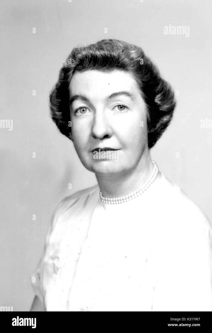 Grayscale portrait photograph, shoulders up, of Blanche Duncan Coll, who received her masters of history from Johns Hopkins University, wearing white dress and pearls, Baltimore, Maryland, 1957. Stock Photo