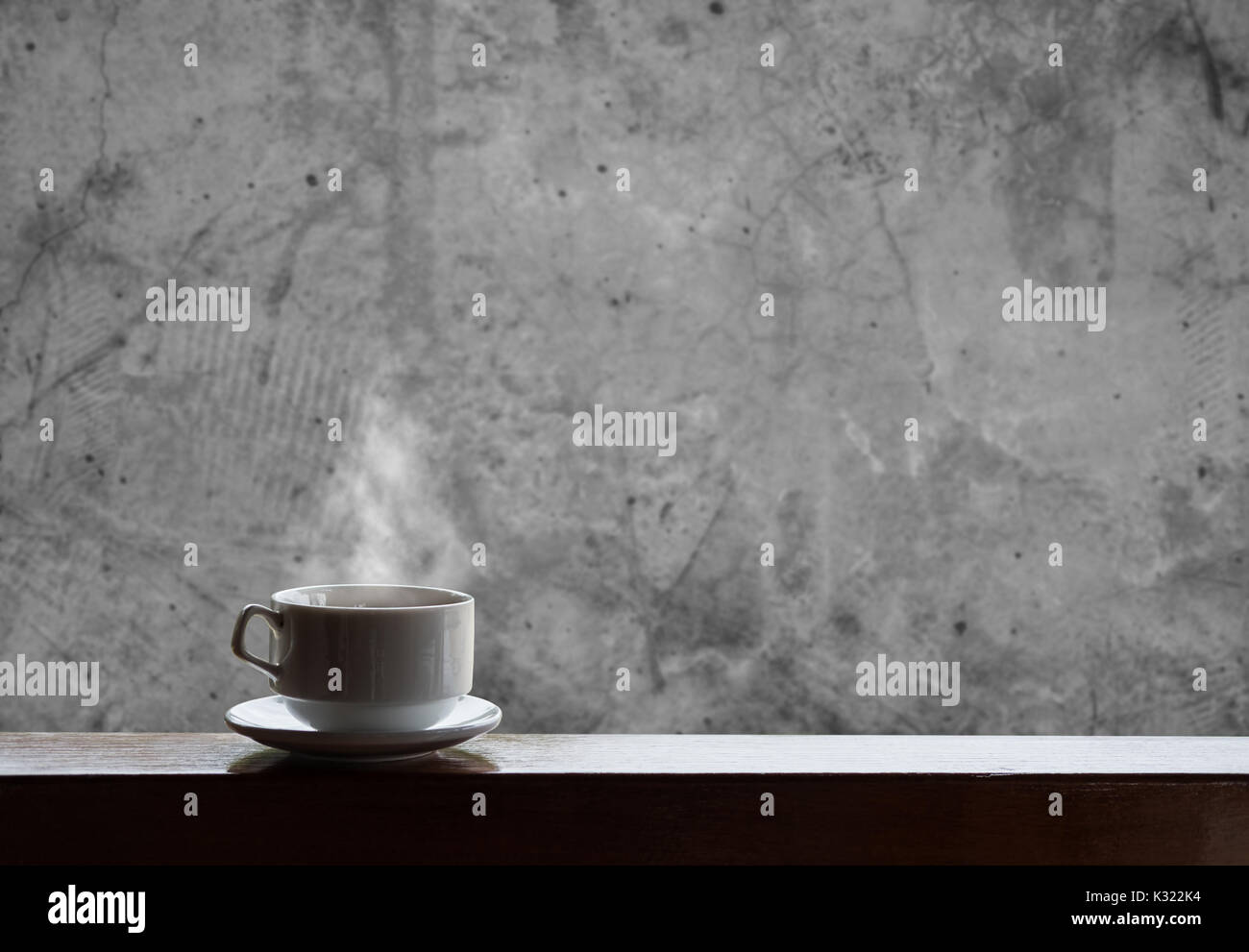 Cup of hot drinks with steam on wood table and concrete background, hot coffee, tea, chocolate and etc. Stock Photo