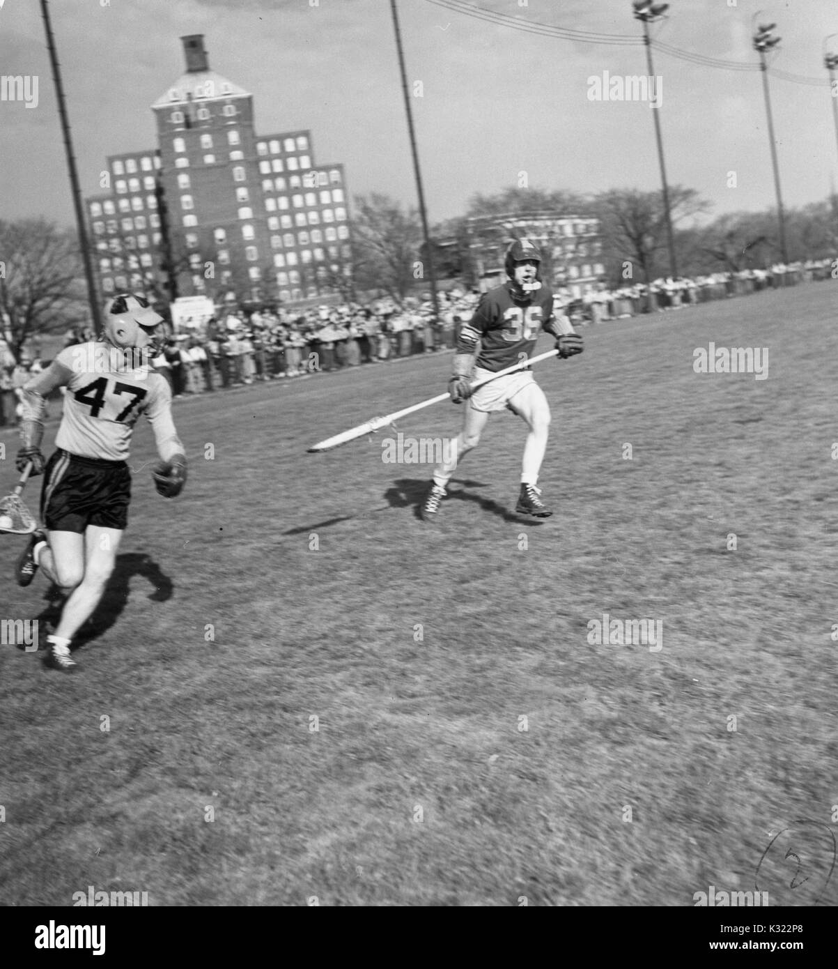 During a lacrosse game, a Loyola defenseman goes for Johns Hopkins Co-captain and attackman Byron Forbush (no, 1951. 47), on the Homewood Field in Baltimore, Maryland. Stock Photo