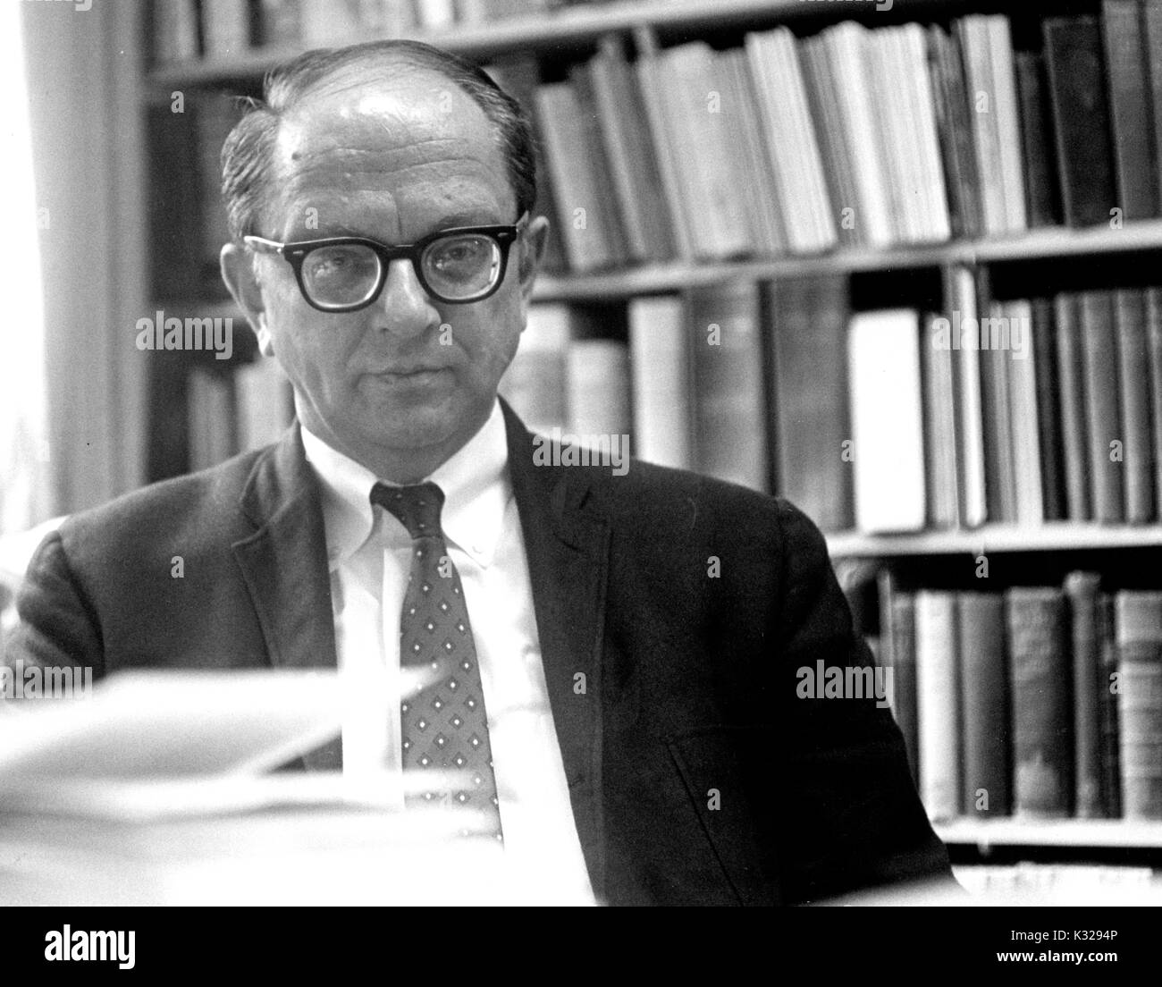 Portrait of American historian and biographer David Herbert Donald sitting in front of bookshelves, 1962. Stock Photo
