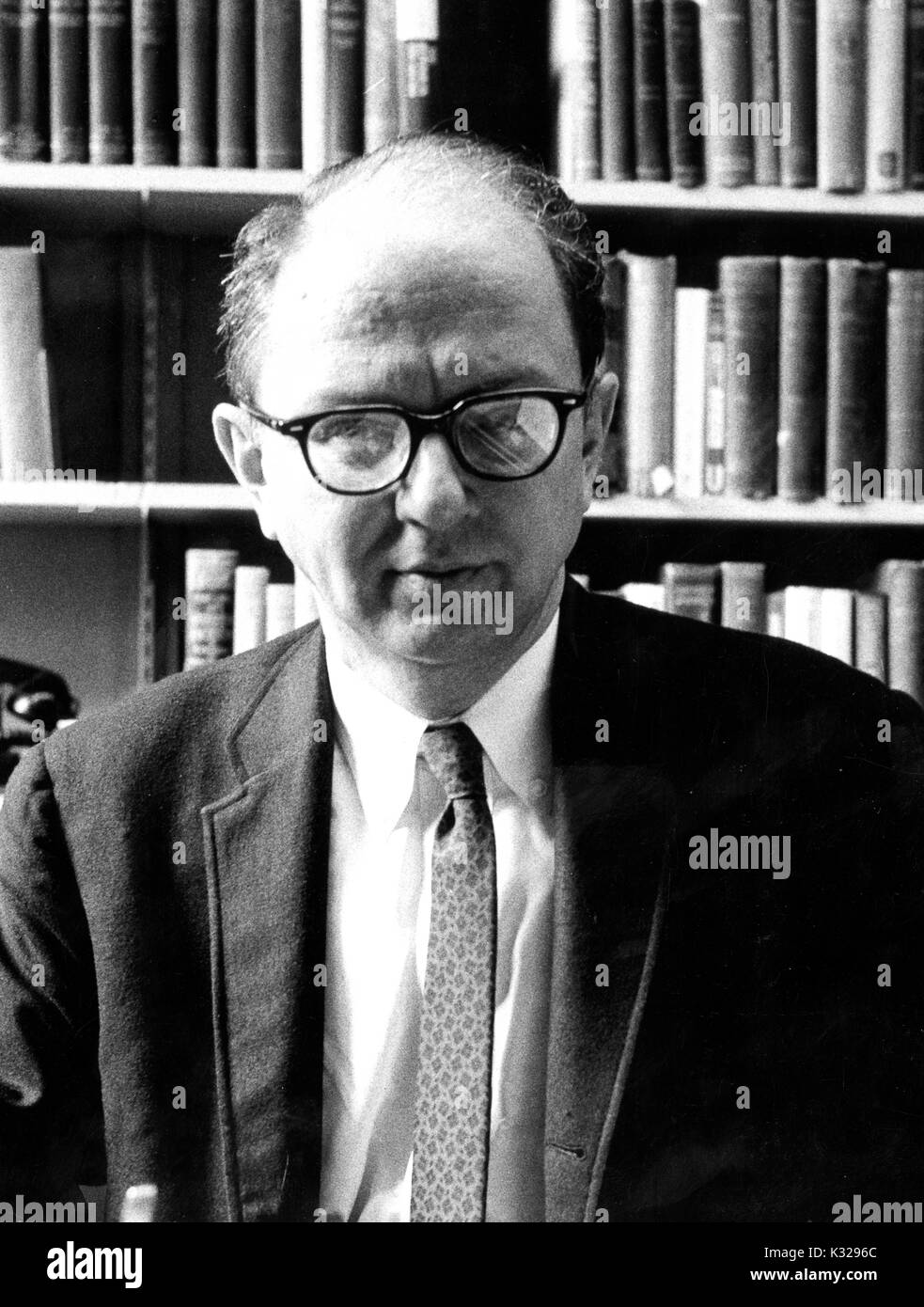 Portrait of American historian and biographer David Herbert Donald sitting in front of bookshelves, 1963. Stock Photo