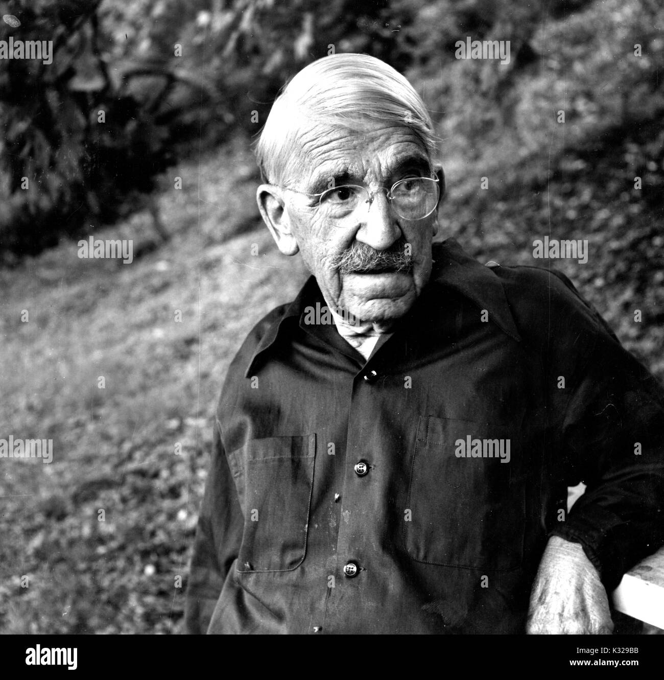 Candid portrait of American philosopher, psychologist, and educational reformer John Dewey standing in a wooded area, 1935. Stock Photo