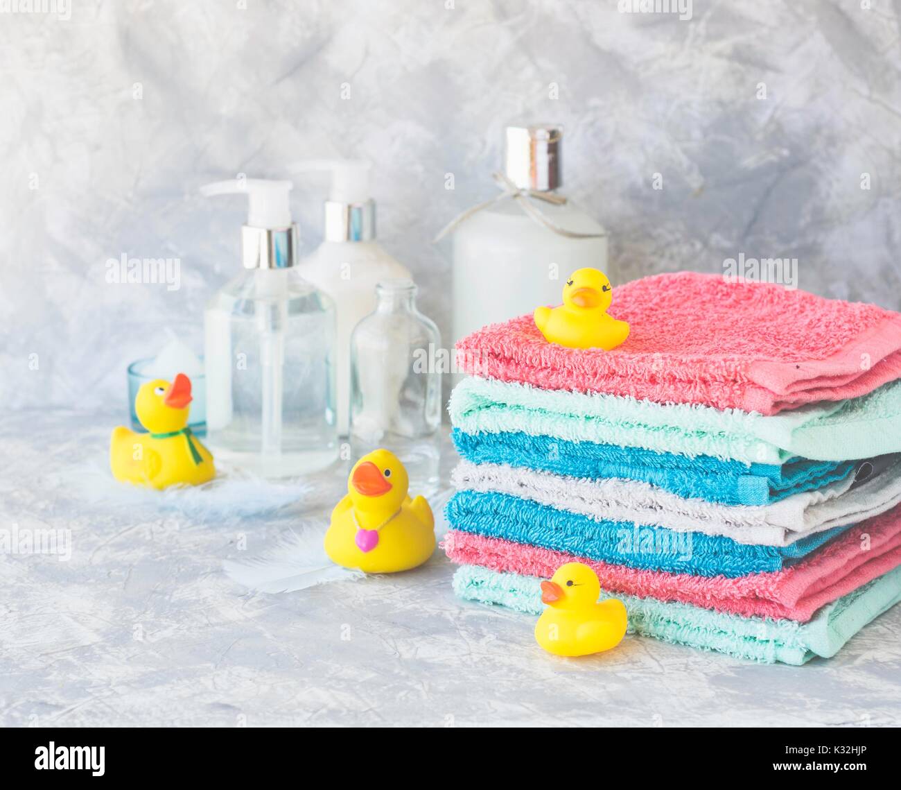 stack of towels with yellow rubber bath ducks and means for bathroom on