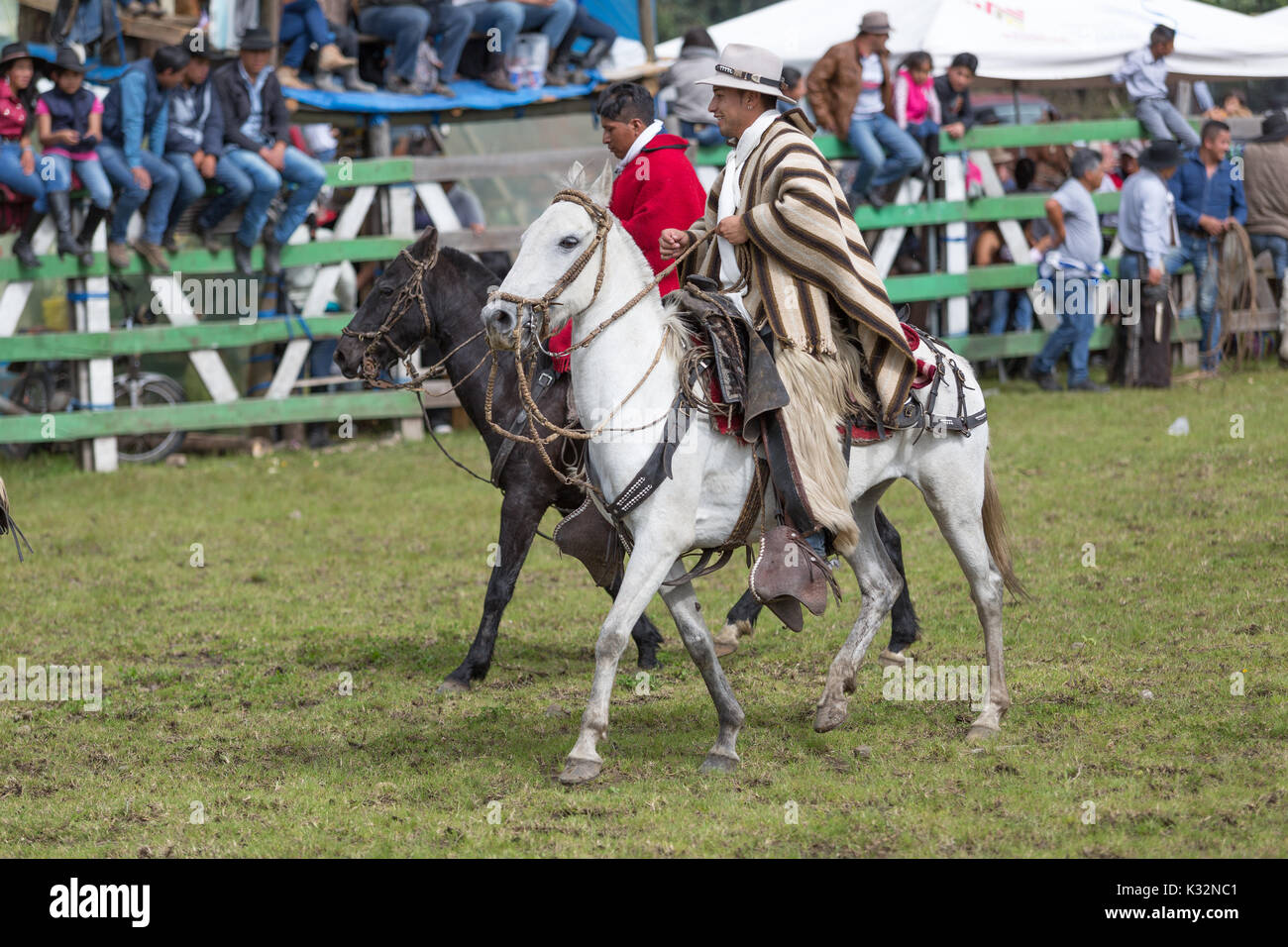 May 27, 2017 Sangolqui, Ecuador: quechua cowboys in poncho riding horse during a rural rodeo at high altitude Stock Photo
