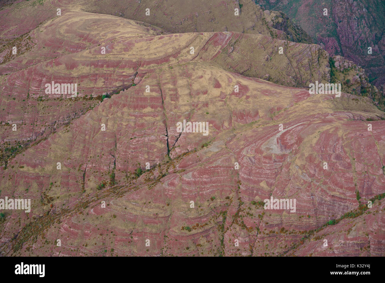 AERIAL VIEW. Stripes of reddish-brown pelite rocks and dry grass above the Cians Gorge. Pierlas, Alpes-Maritimes, France. Stock Photo