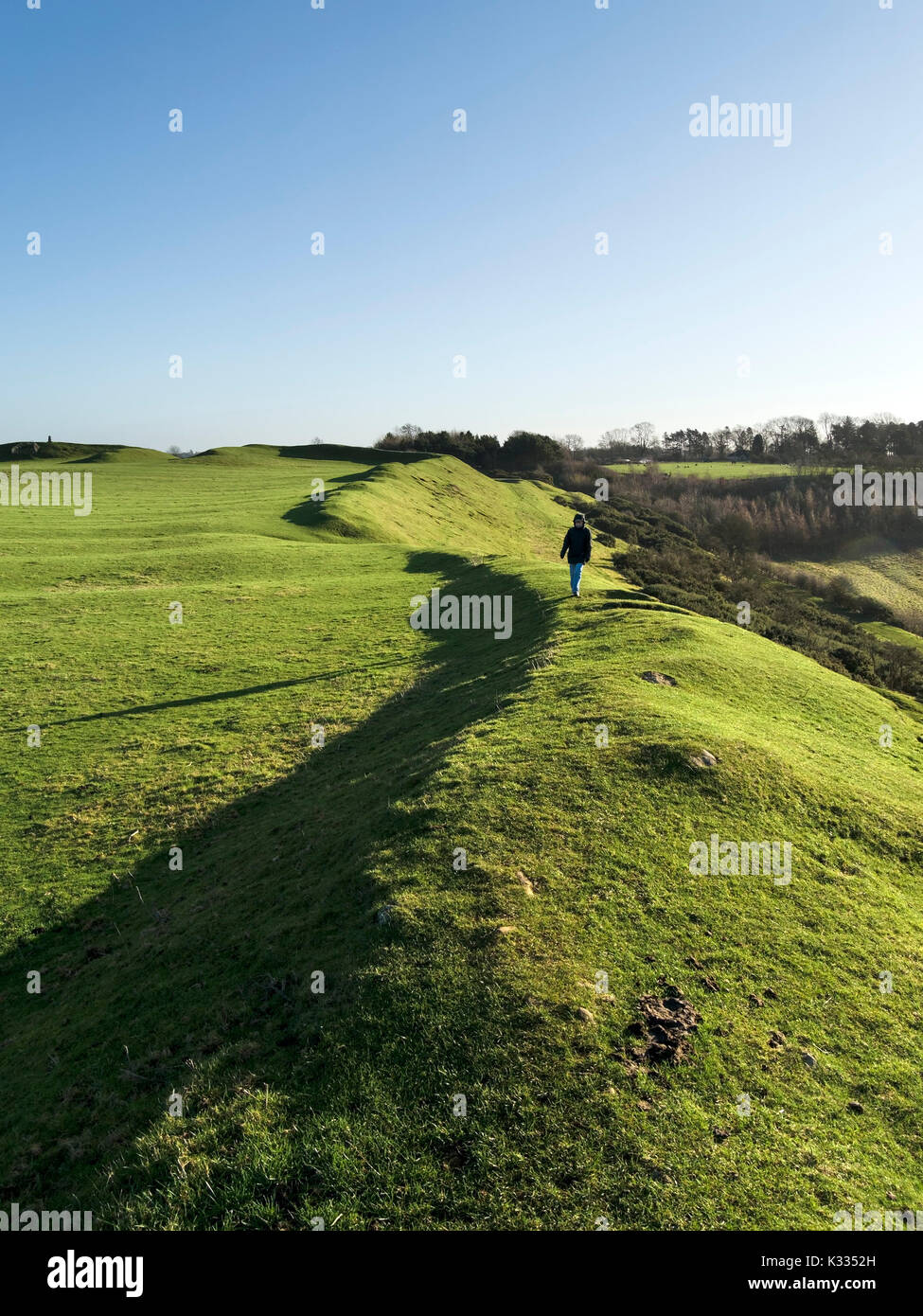 Low sunlight highlights embankment earthworks on Iron Age Hill Fort, ancient monument, Burrough Hill, Leicestershire. Stock Photo