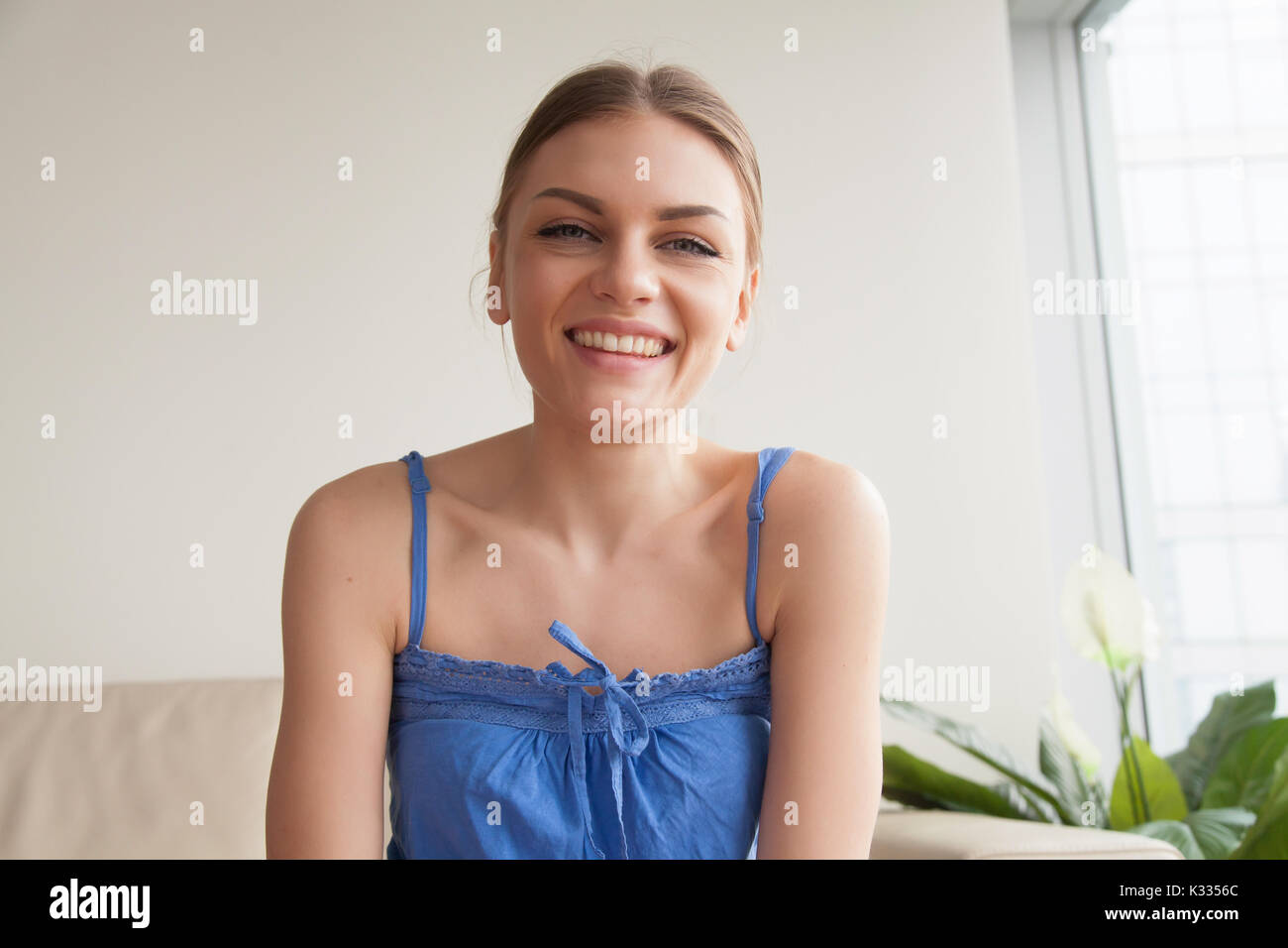 Pleased woman talking with friends online Stock Photo