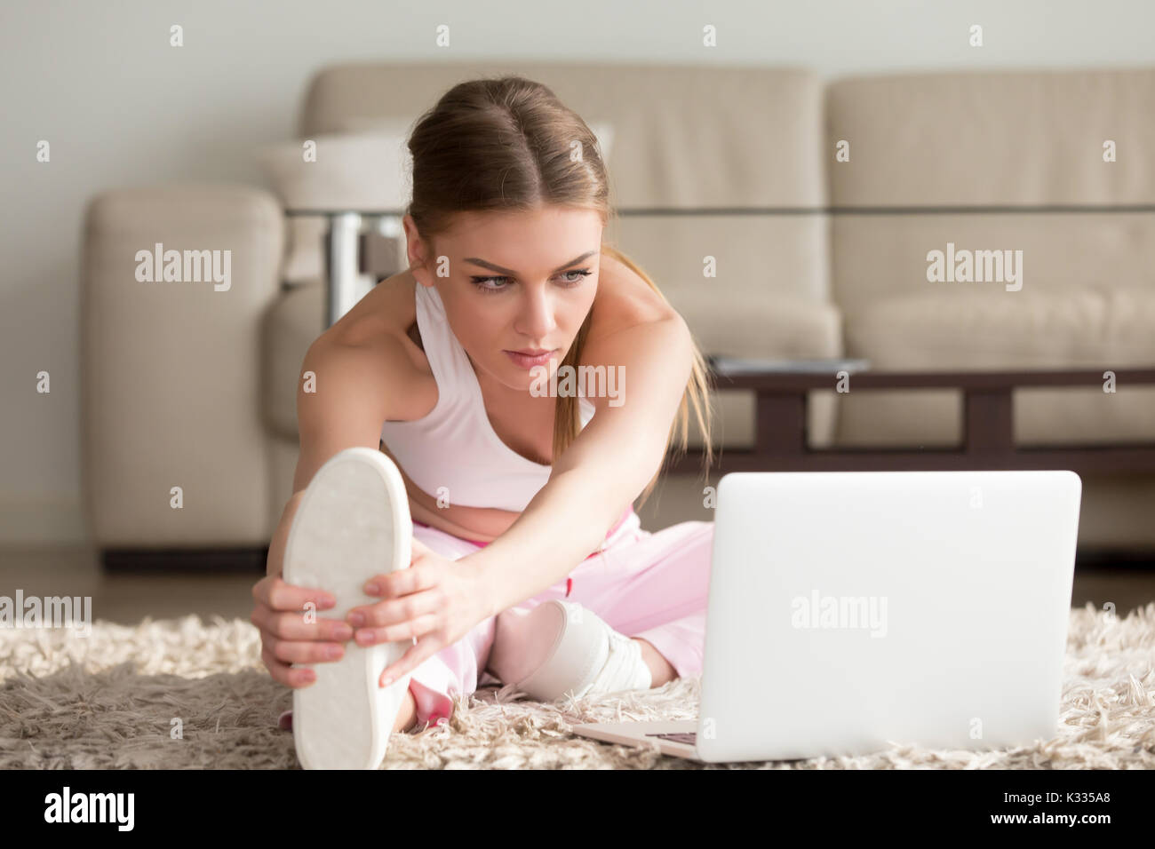 Flexible lady doing physical exercises at home Stock Photo