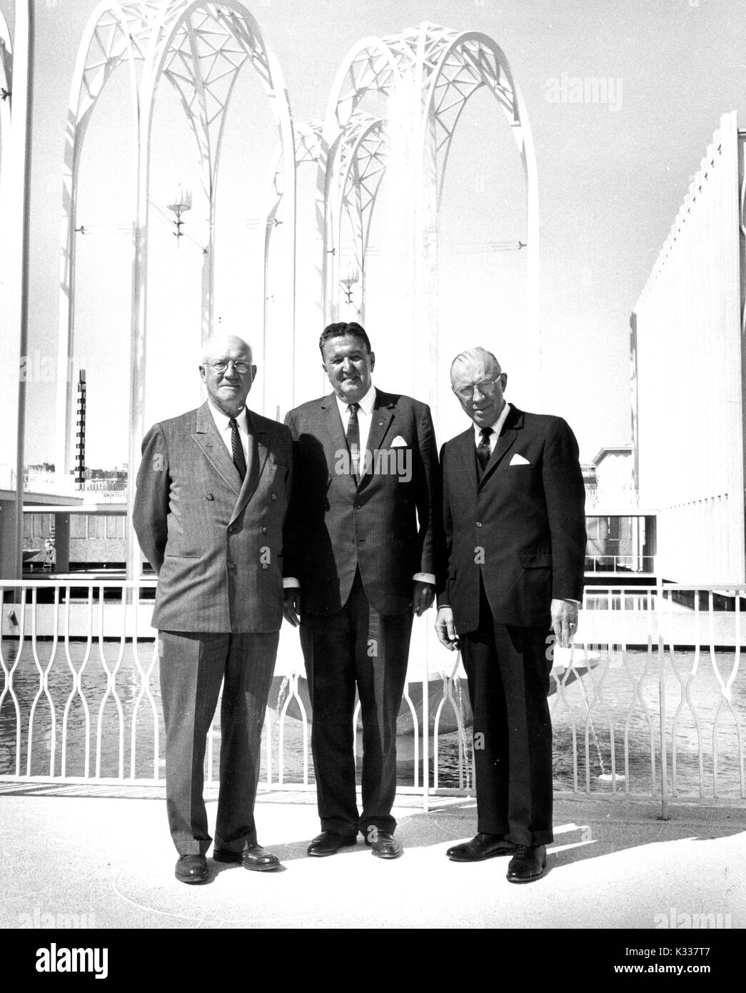 Group photograph of Johns Hopkins University President Milton S. Eisenhower (right), his brother Edgar N. Eisenhower (center), and Seattle attorney and public figure Joseph Edward Gandy (left) standing in front of arches and a fountain at the 1962 Seattle World's Fair, 1962. Stock Photo