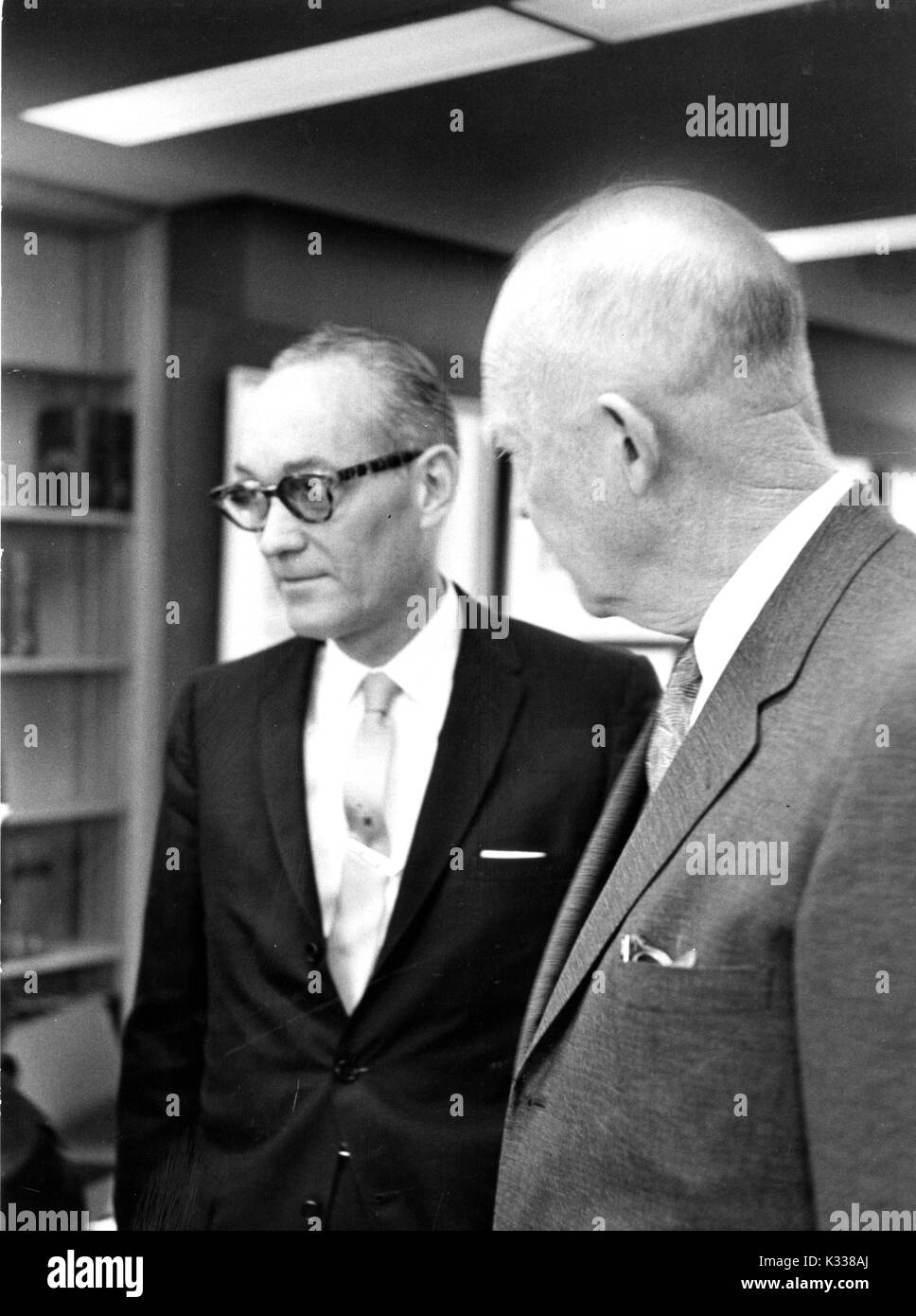 Candid portrait of 34th President of the United States Dwight D Eisenhower (right) speaking with State Department official Francis Orlando Wilcox (center) in the Milton S. Eisenhower Library on the Homewood campus of Johns Hopkins University in Baltimore, Maryland, 1965. Stock Photo