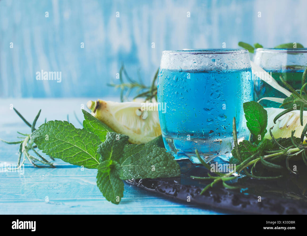 Blue curacao liqueur or sambuca with lemon on the wooden table, selective focus Stock Photo