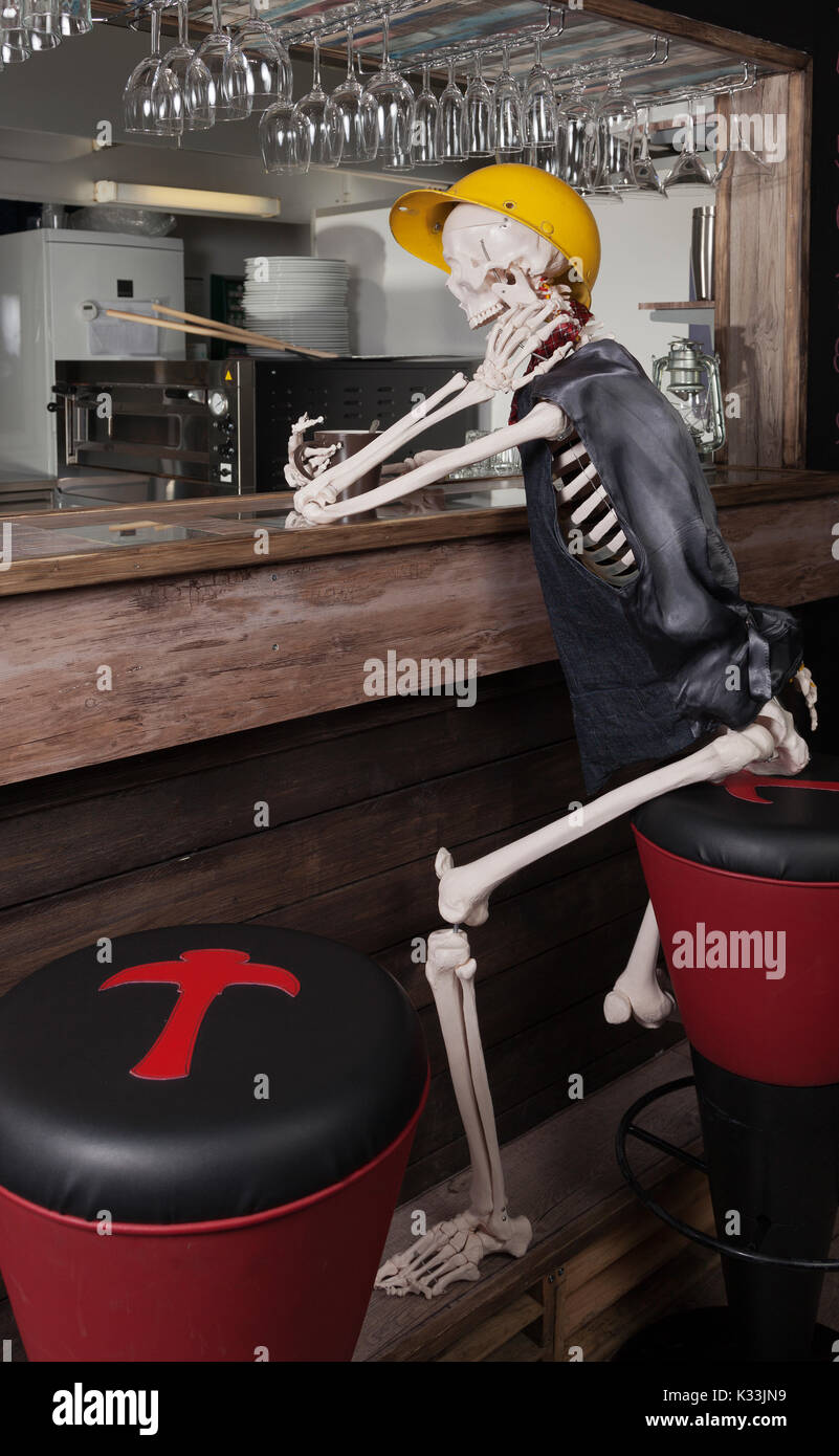 Oscari Oravikoski, the skeleton, is sitting in bar, drinking coffee and ordering pizza Stock Photo