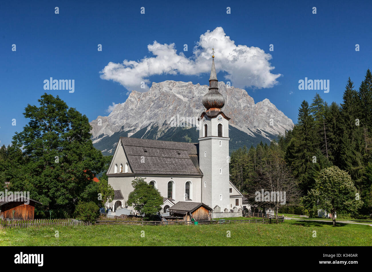 Typical church of alpine village surrounded by peaks and woods Garmisch Partenkirchen Oberbayern region Bavaria Germany Europe Stock Photo